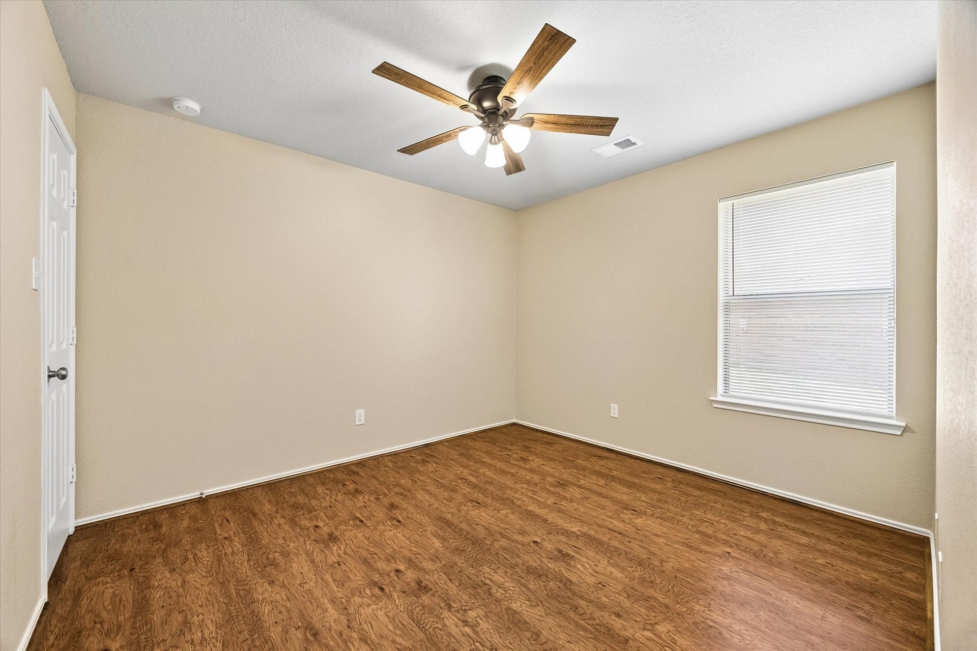18127 Hillock Glen Lane, Cypress, TX 77429 Secondary bedroom featuring wood-look flooring, fresh interior paint, and a NEW ceiling fan.