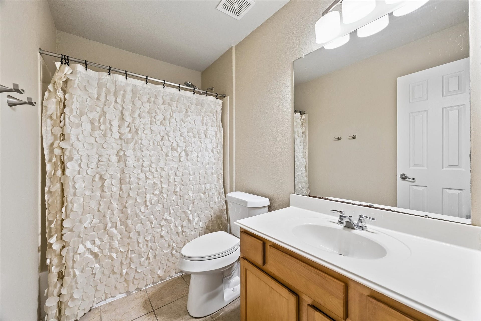 18127 Hillock Glen Lane, Cypress, TX 77429 Secondary bathroom featuring a tub and shower combination, single-sink vanity, and tile flooring.