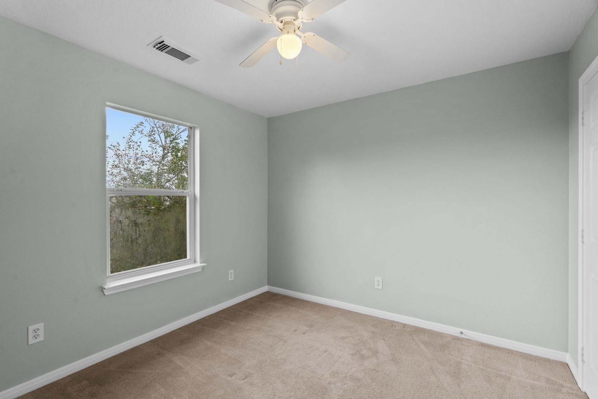 5800 Winding Brook Drive, Dickinson, TX 77539 Cozy bedroom with soft green walls, plush carpet, and a ceiling fan.