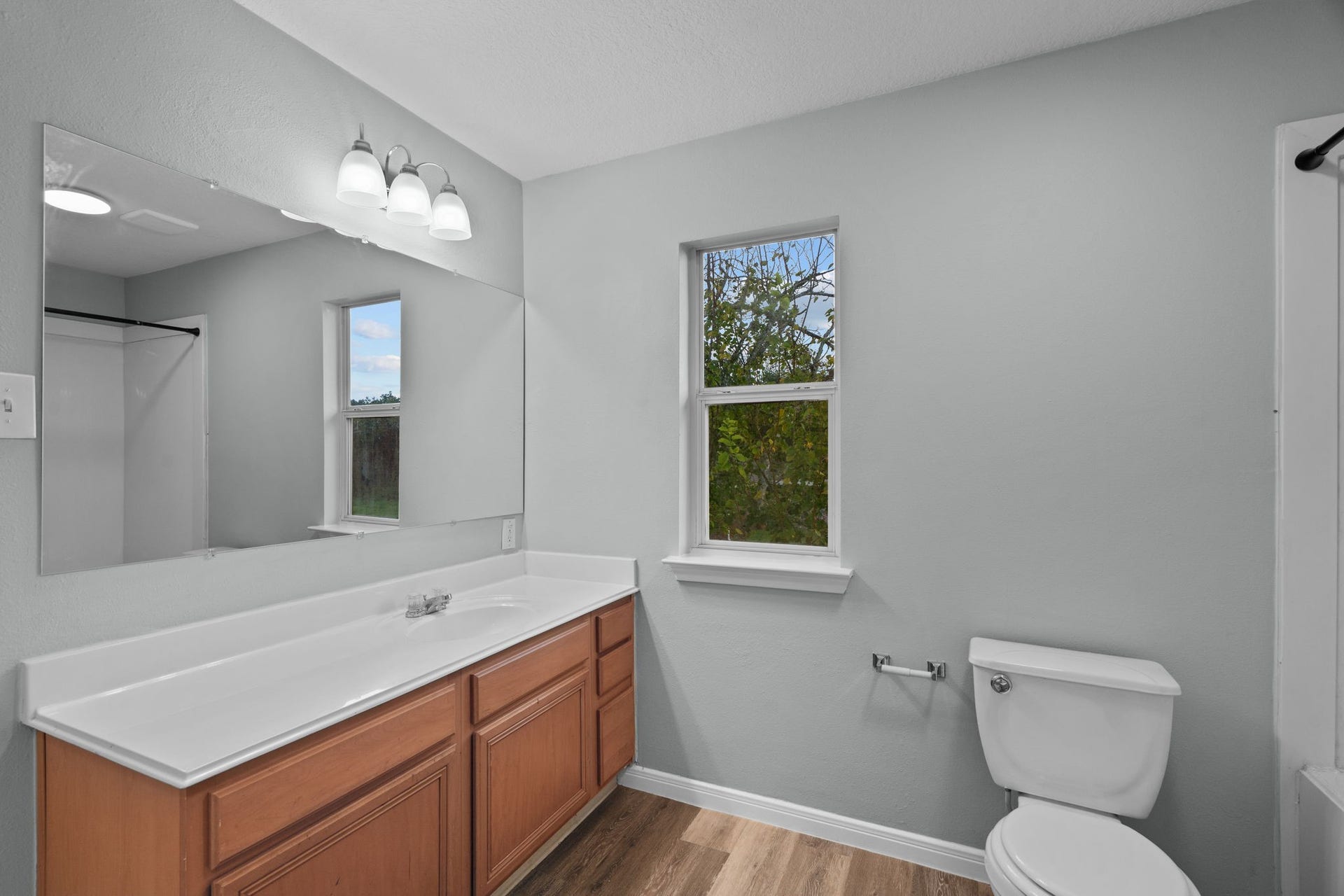 5800 Winding Brook Drive, Dickinson, TX 77539 Bright and modern bathroom with a spacious vanity, sleek mirror, and natural light.
