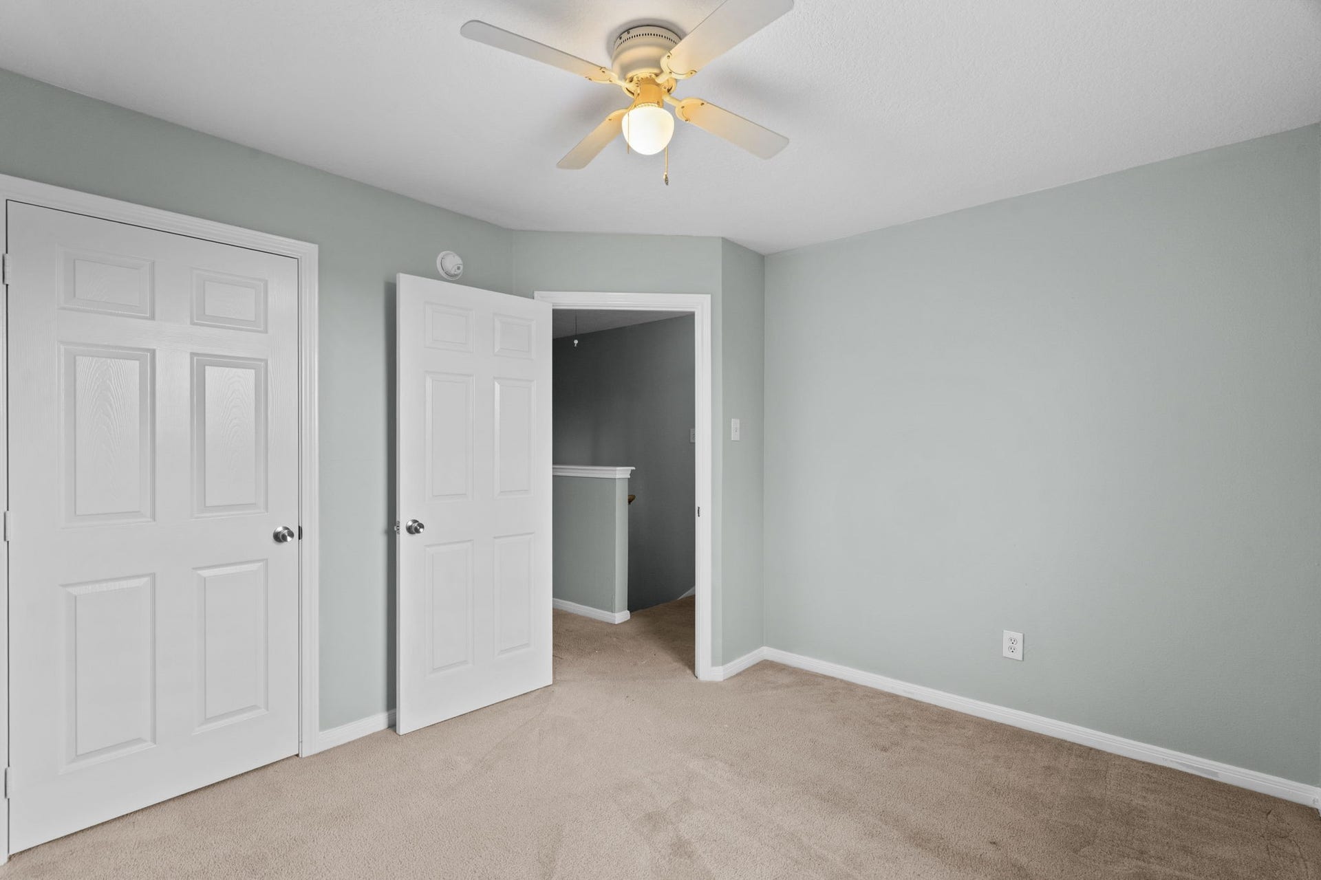 5800 Winding Brook Drive, Dickinson, TX 77539 Bright and inviting bedroom featuring soft carpet, calming gray walls, and a ceiling fan for comfort.
