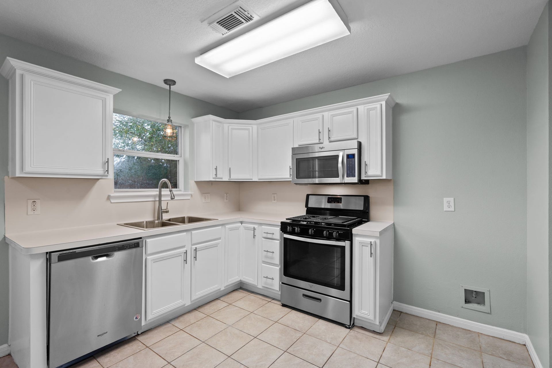 5800 Winding Brook Drive, Dickinson, TX 77539 Bright kitchen with modern stainless steel appliances, white cabinetry, and ample counter space.