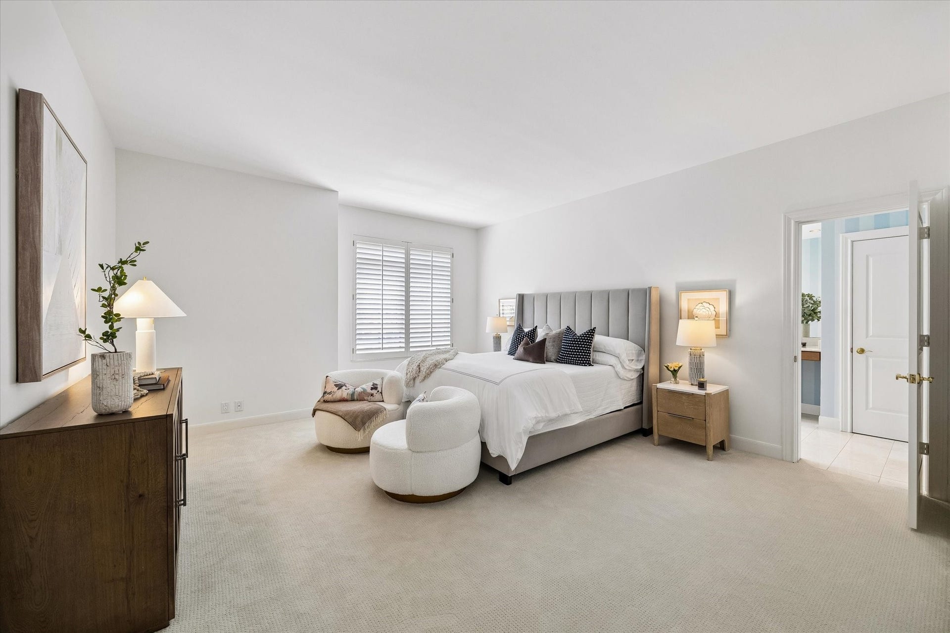 Spacious primary bedroom with plantation shutters on windows. The primary bedroom has a large and well appointed walk in closet.