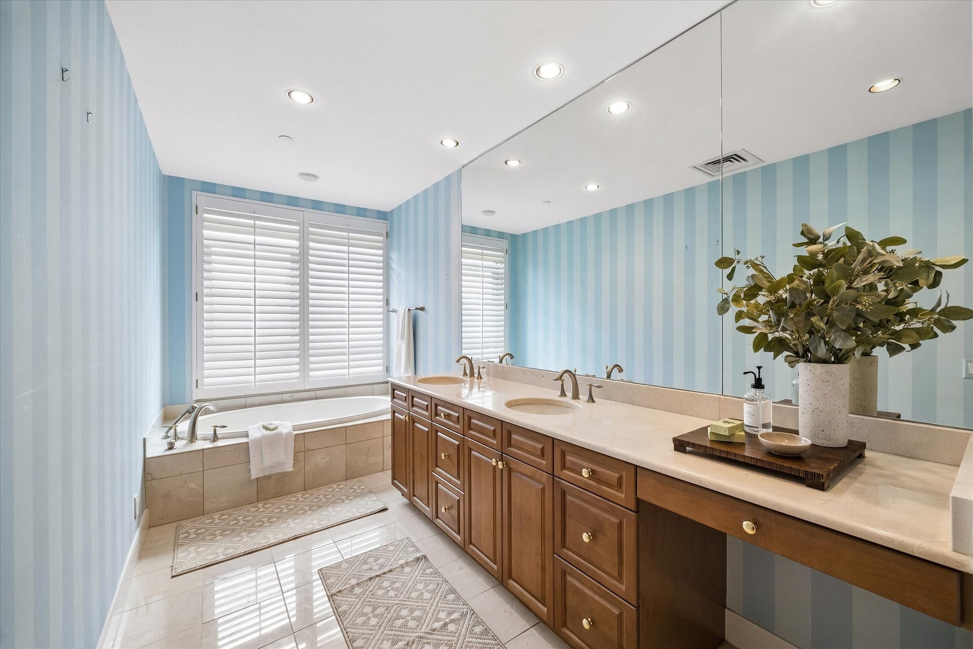 Primary bathroom with double sinks, vanity space, and spa tub.
