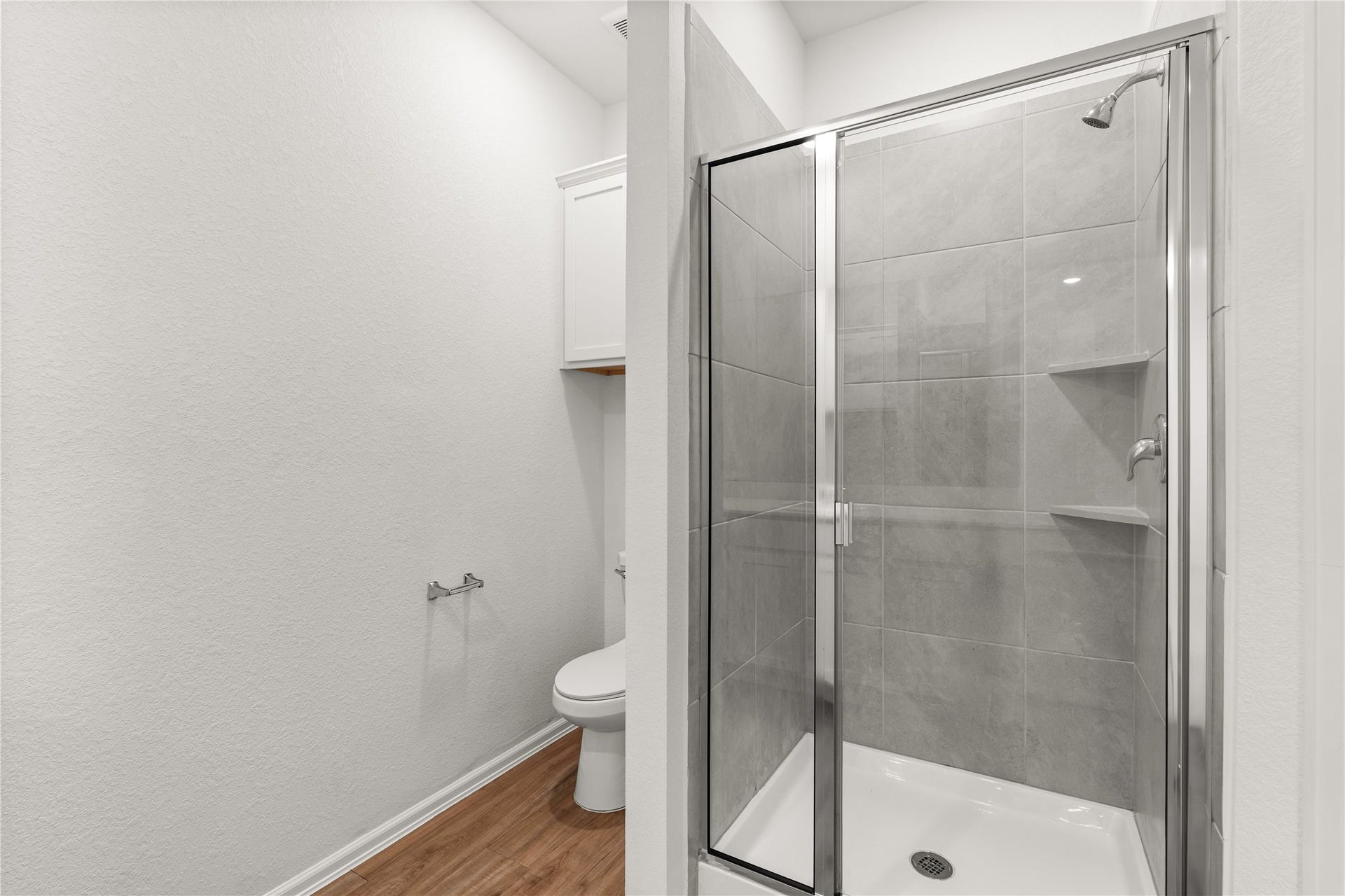 1938 Foxtail Creek Ct, Crosby, TX 77532 The walk in shower features tile surrounds, built in storage shelves, and a framed glass shower door.