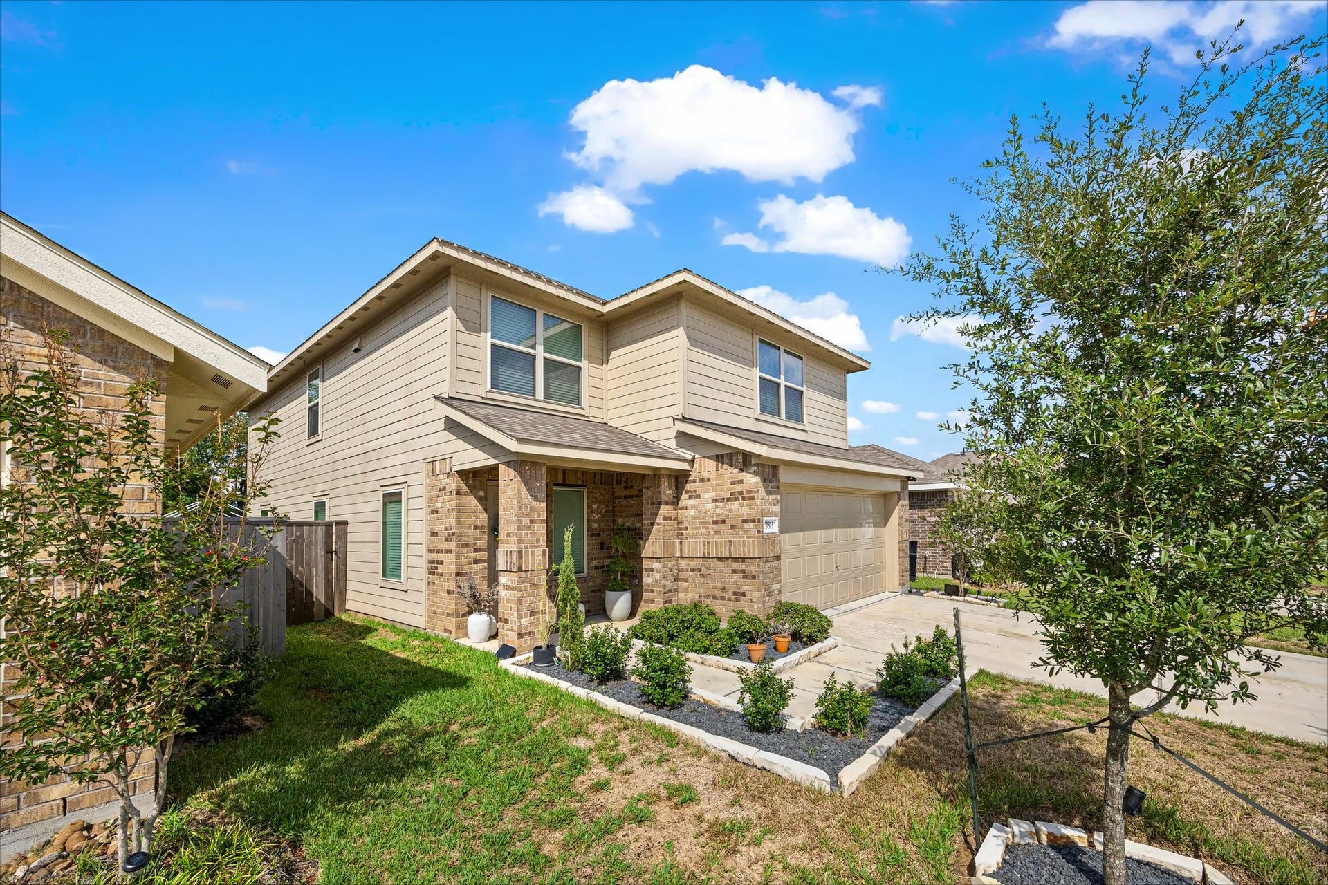 17811 Pemswood Drive, Hockley, TX 77447 Front elevation with mature landscaping and stone-edged flower beds