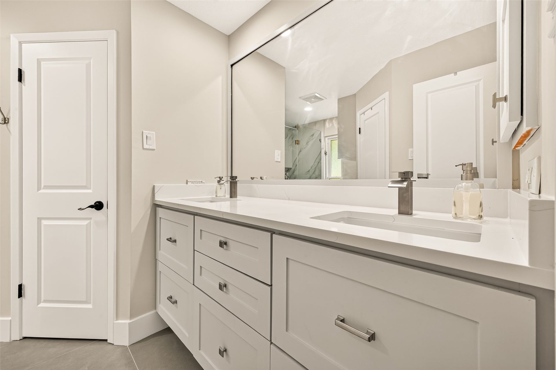 2123 Collingsfield Drive, Sugar Land, TX 77478 Sleek primary bathroom features a modern double vanity with ample storage, complemented by a large mirror and elegant fixtures, creating a bright and inviting spa-like space.