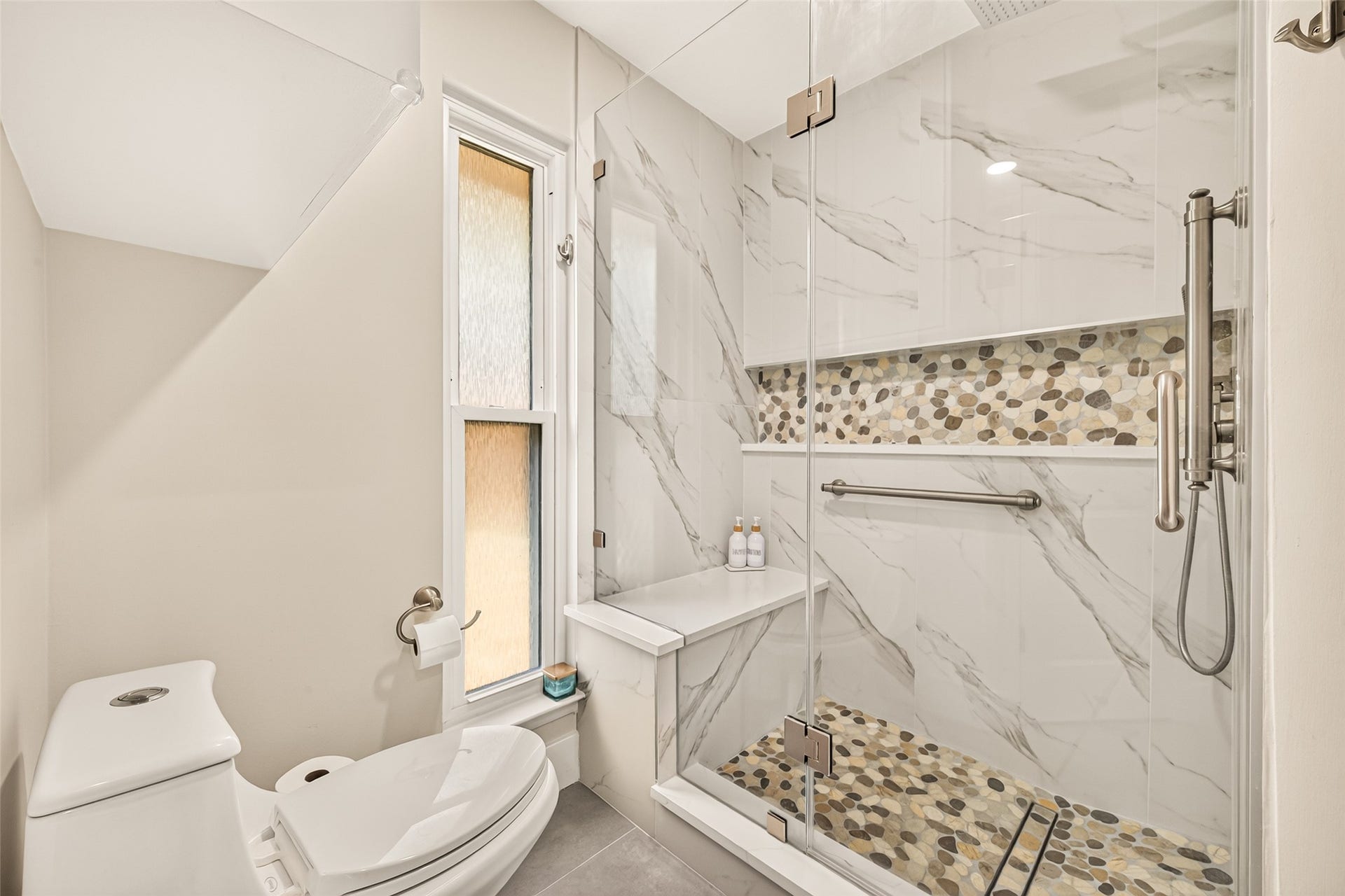 2123 Collingsfield Drive, Sugar Land, TX 77478 Updated spacious glass-enclosed shower with stylish pebble tile accents and a sleek bench