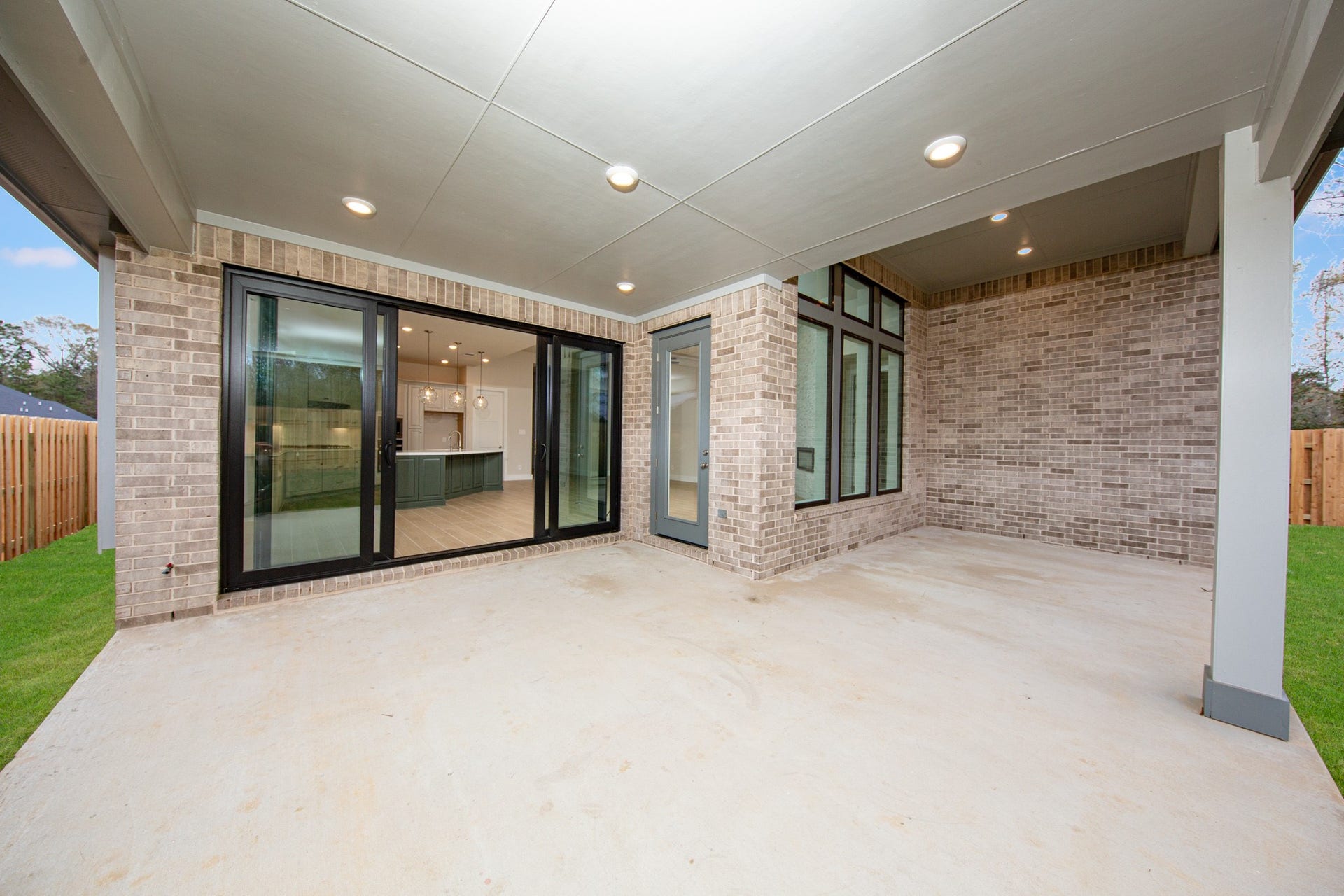1915 Langford Street, Montgomery, TX 77316 Step outside to the covered rear patio, the perfect extension of your indoor living space for year-round enjoyment. The greatest feature is the expansive black-frame multi-slide patio doors!