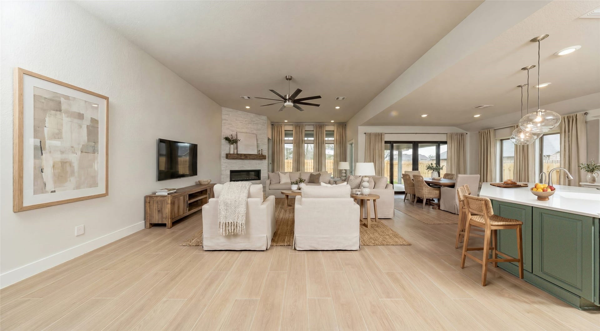 1915 Langford Street, Montgomery, TX 77316 Enjoy an open, airy living experience! The Great Room features a stunning electric fireplace with stacked stone - floor to ceiling. The oversized windows flood the entire space with abundant natural light and frame a picturesque view of the serene backyard. A large ceiling fan provides comfort all year long. *Virtually Staged