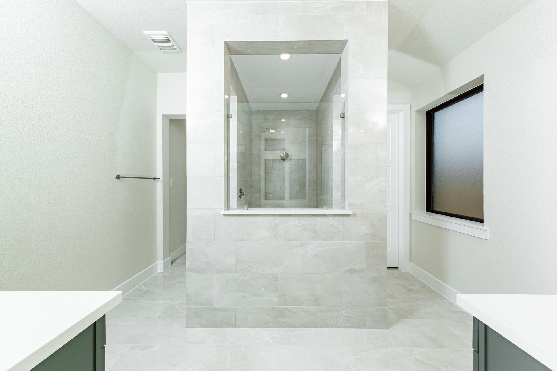 1915 Langford Street, Montgomery, TX 77316 This stunningly updated primary bathroom is truly move-in ready! It features a large walk-in shower with tile surround, stained cabinetry with light countertops, dual vanities, mirrors, a generous walk-in closet with built-in shelving, soaring ceilings, custom paint, and sleek modern fixtures.
