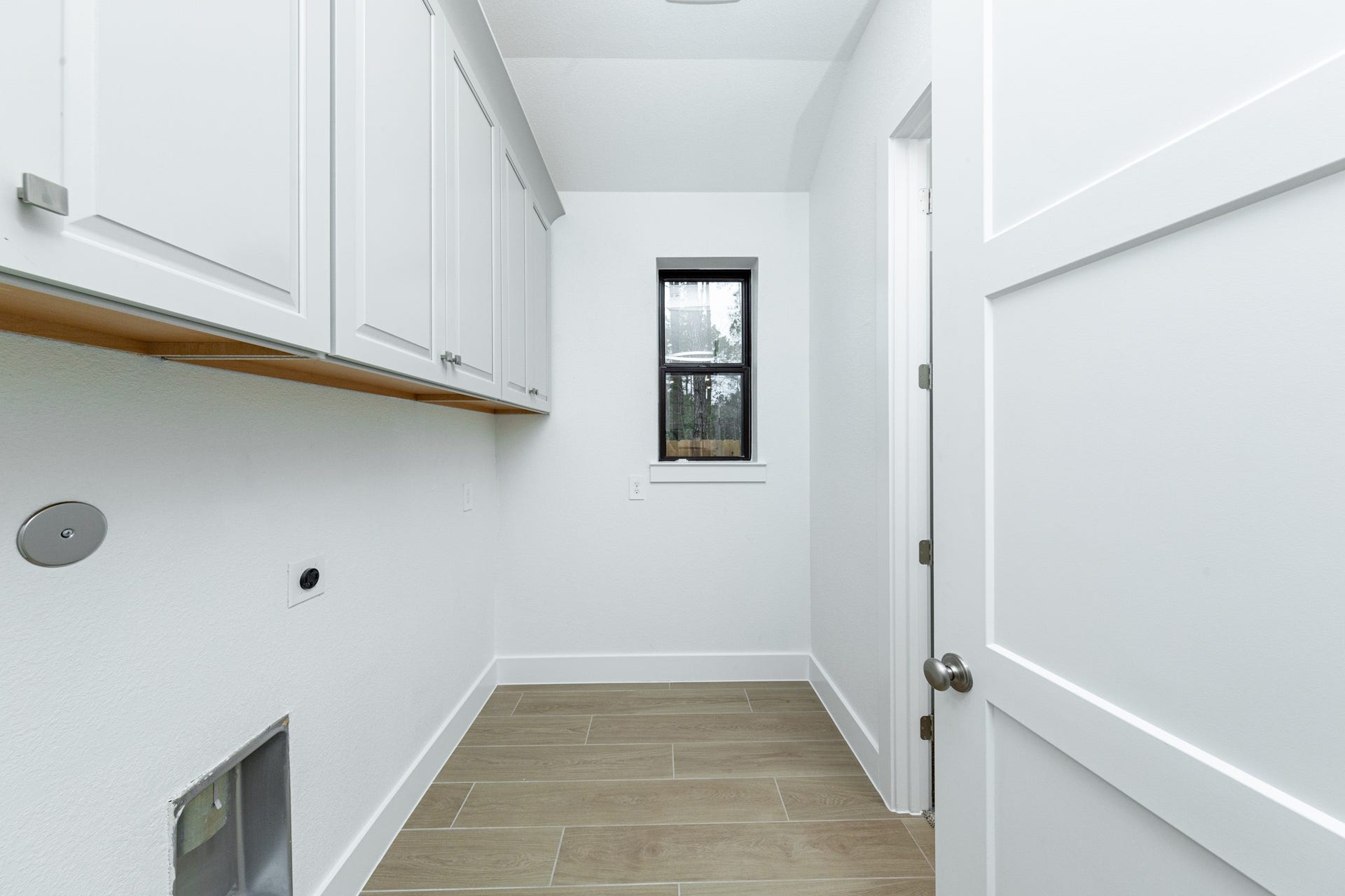 1915 Langford Street, Montgomery, TX 77316 This bright and functional laundry room is conveniently located and ready for your appliances. It features clean white walls and trim, a window providing abundant natural light, and the gorgeous wood tile flooring for durability.