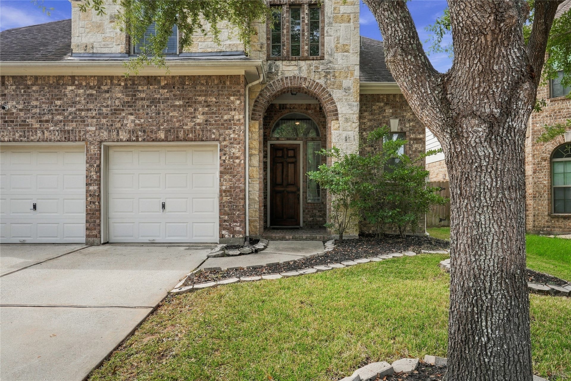 20815 S Blue Hyacinth Drive, Cypress, TX 77433 Come on in! A welcoming front entry sits beneath the covered porch, surrounded by mature landscaping and a charming mix of brick and stone.