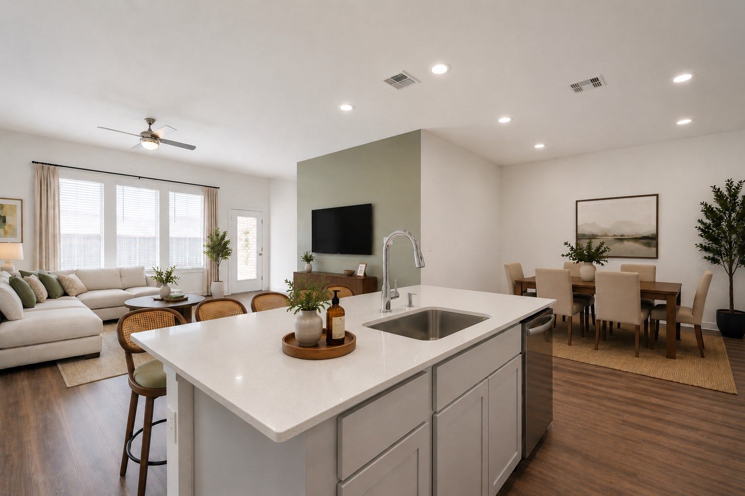 Beautifully virtual staged open-concept living featuring a spacious chef's kitchen with quartz island, designer cane-back bar stools, formal dining area, and a bright living room with a modern sectional, creating an inviting space perfect for everyday living and entertaining.