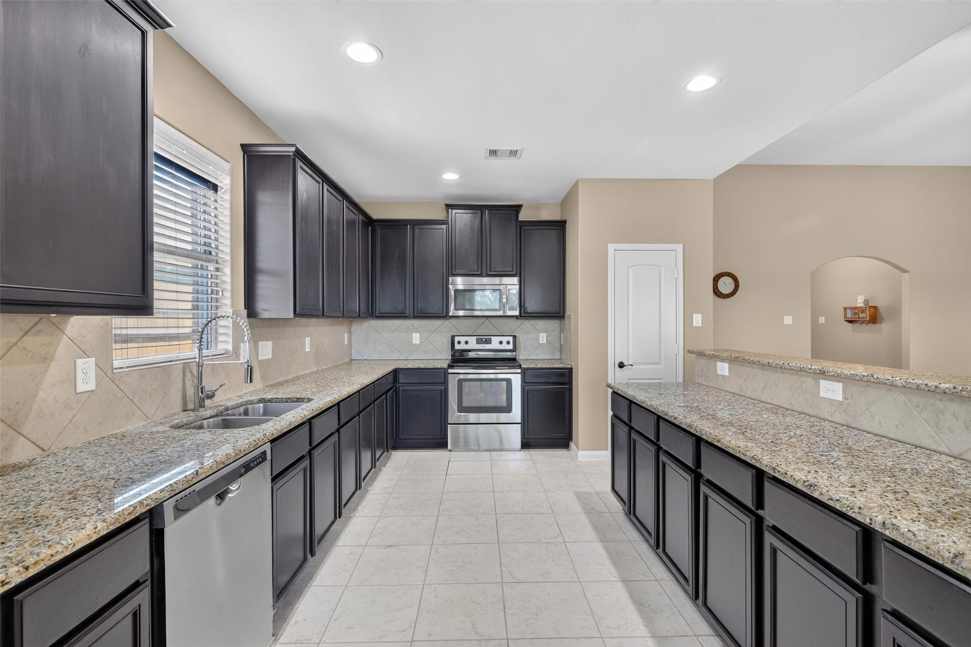 22907 Gentle Shadow Drive, Hockley, TX 77447 While a stainless-steel refrigerator and dishwasher complement the rich, dark cabinetry. Expansive counters and abundant cabinet storage provide room for meal preparation and everyday essentials. A raised breakfast bar offers space for casual dining and conversation,