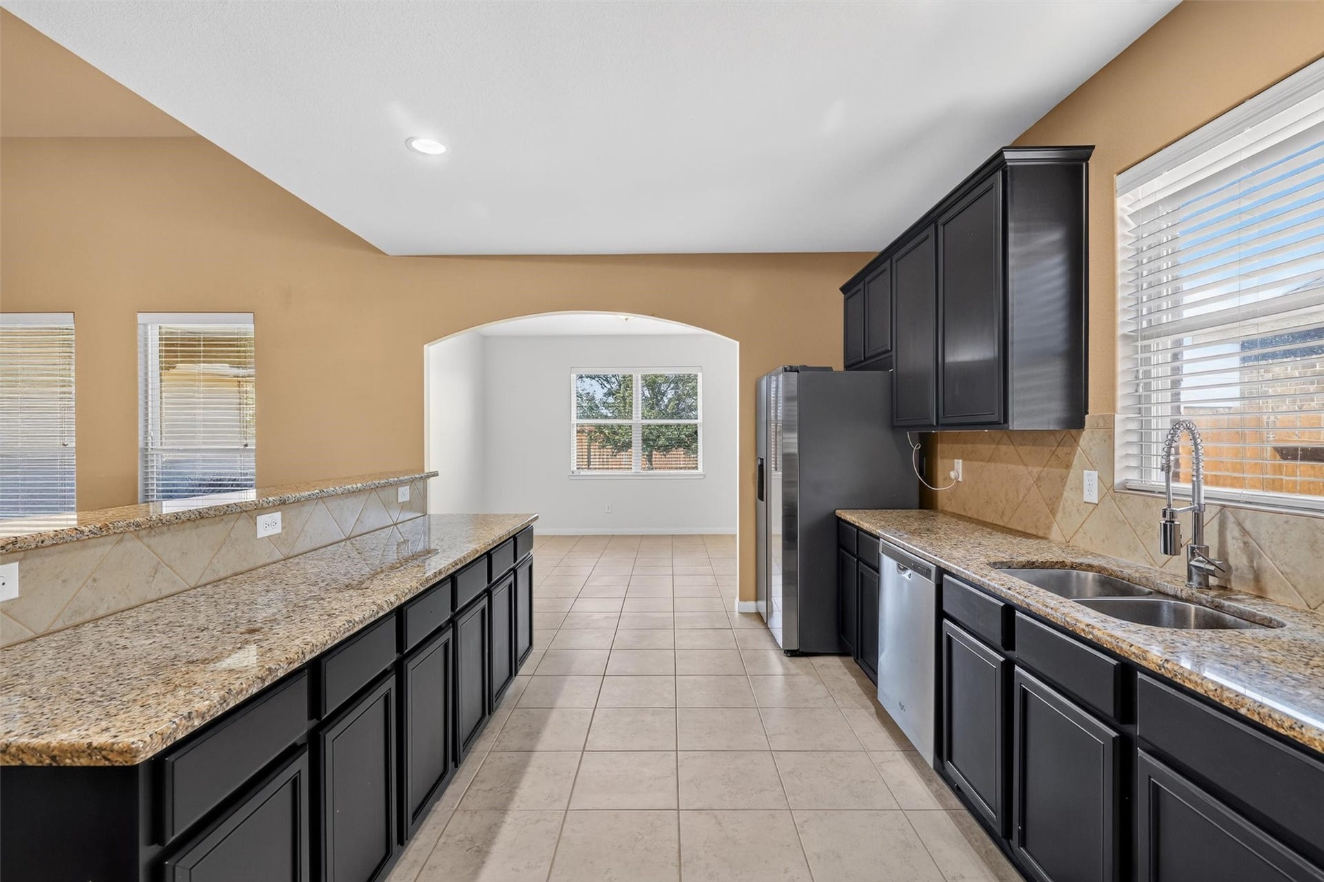 22907 Gentle Shadow Drive, Hockley, TX 77447 Expansive counters, abundant dark cabinetry, and a raised breakfast bar offer plenty of space for meal preparation, storage, and casual dining.