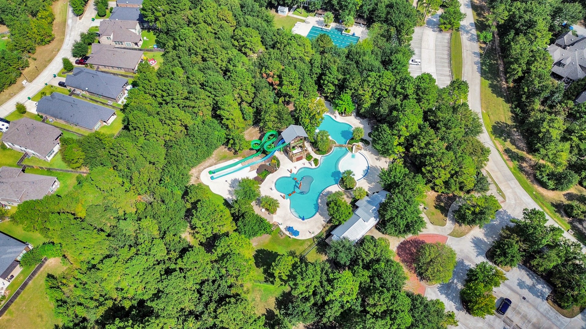 143 Pronghorn Place, Montgomery, TX 77316 Nestled in a lush green setting, this community features a stunning pool area with winding water slides and ample lounging space, perfect for relaxation and recreation.