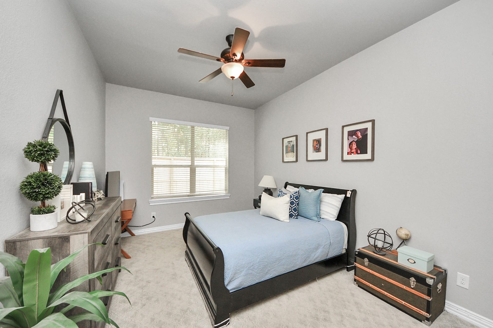 143 Pronghorn Place, Montgomery, TX 77316 Cozy bedroom featuring a stylish dark bed frame, modern decor, and ample natural light from a large window.
