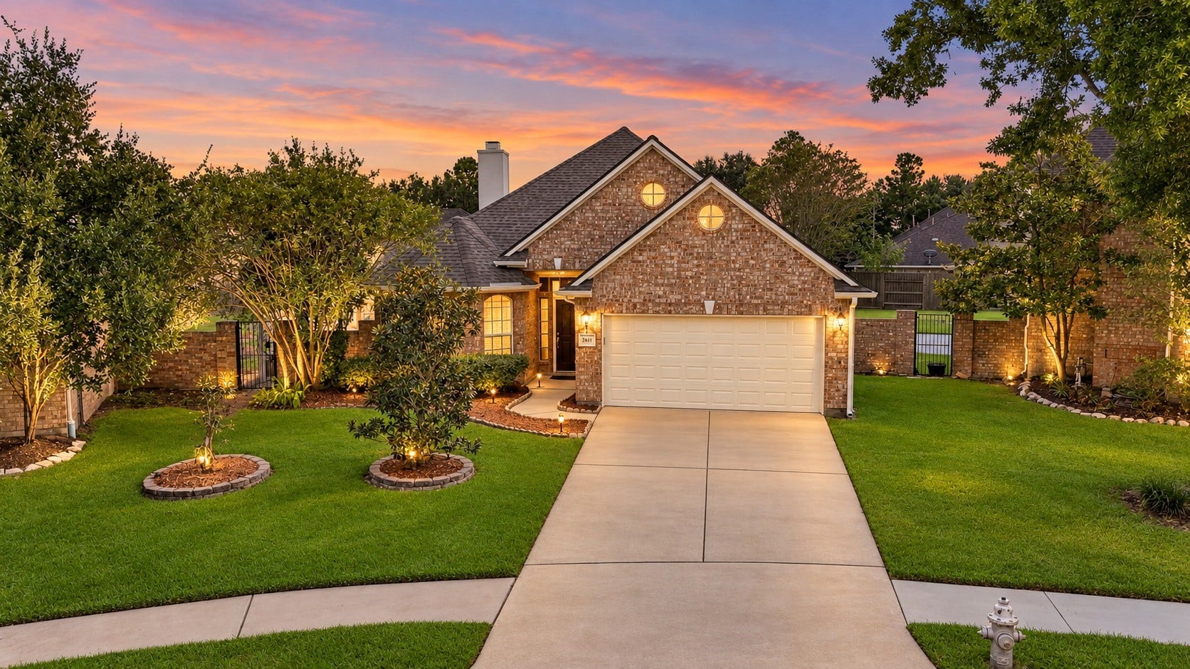 2611 Oxhill Court, Pearland, TX 77584 This inviting brick home features beautiful curb appeal with mature trees, lush landscaping, and a spacious two-car garage. The bright twilight sky creates a striking backdrop, while warm exterior and interior lighting highlights the homes architectural details and welcoming front entry.