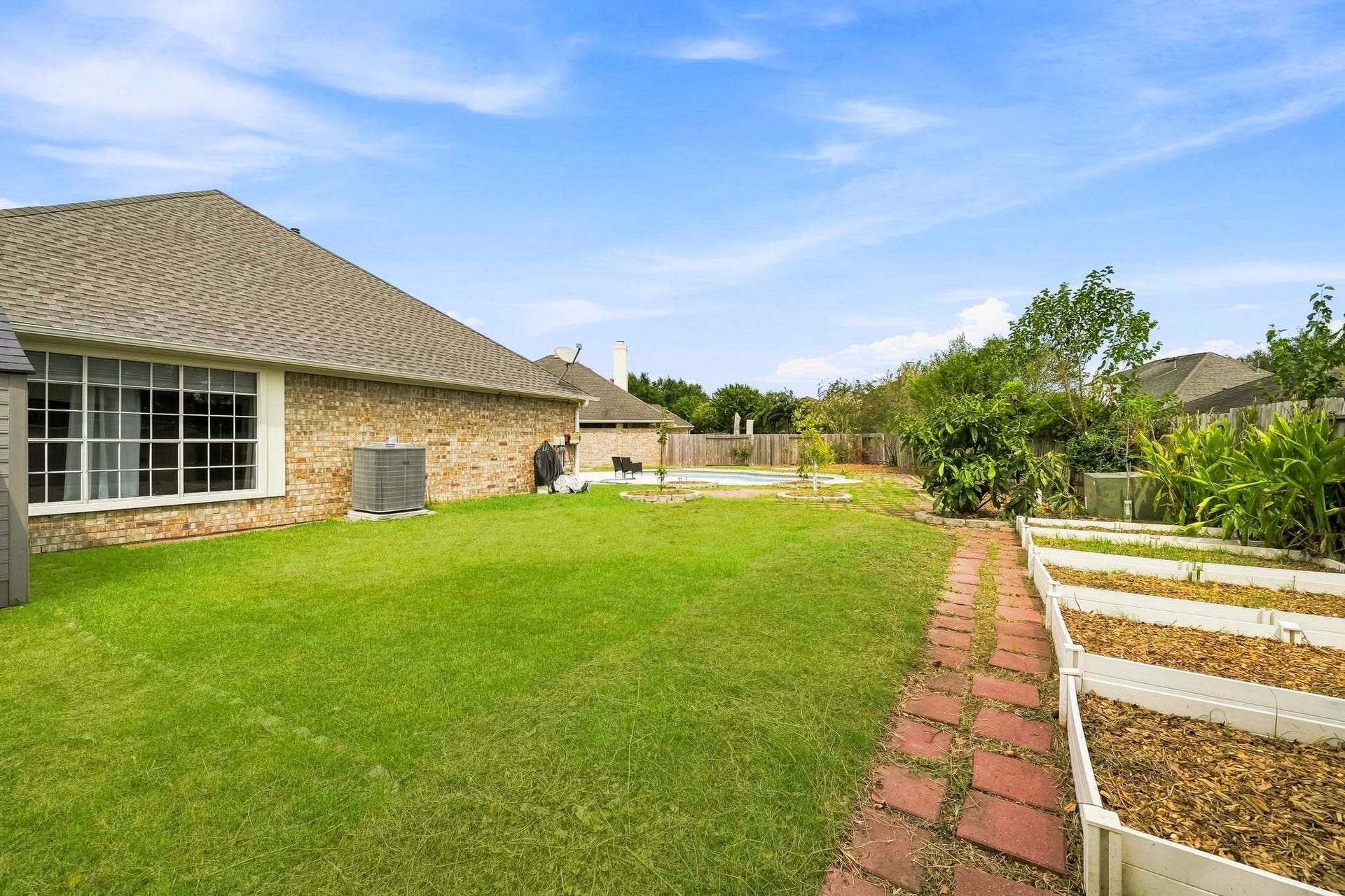 2611 Oxhill Court, Pearland, TX 77584 The spacious yard features extensive paver pathways, multiple landscaped planting areas, mature trees, and plenty of open space for outdoor activities and entertaining.