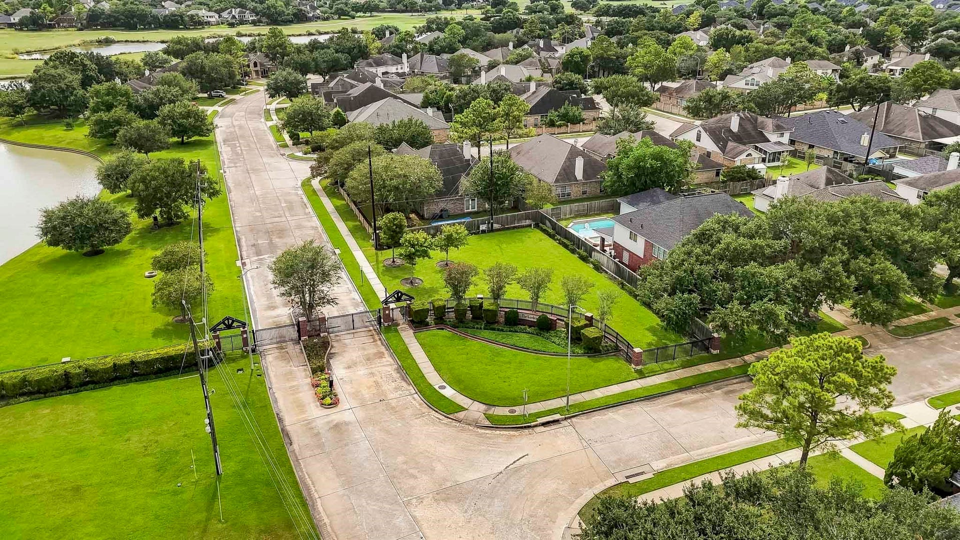 2611 Oxhill Court, Pearland, TX 77584 This aerial view showcases the beautiful gated community, featuring a private controlled entrance surrounded by manicured green spaces and mature landscaping.