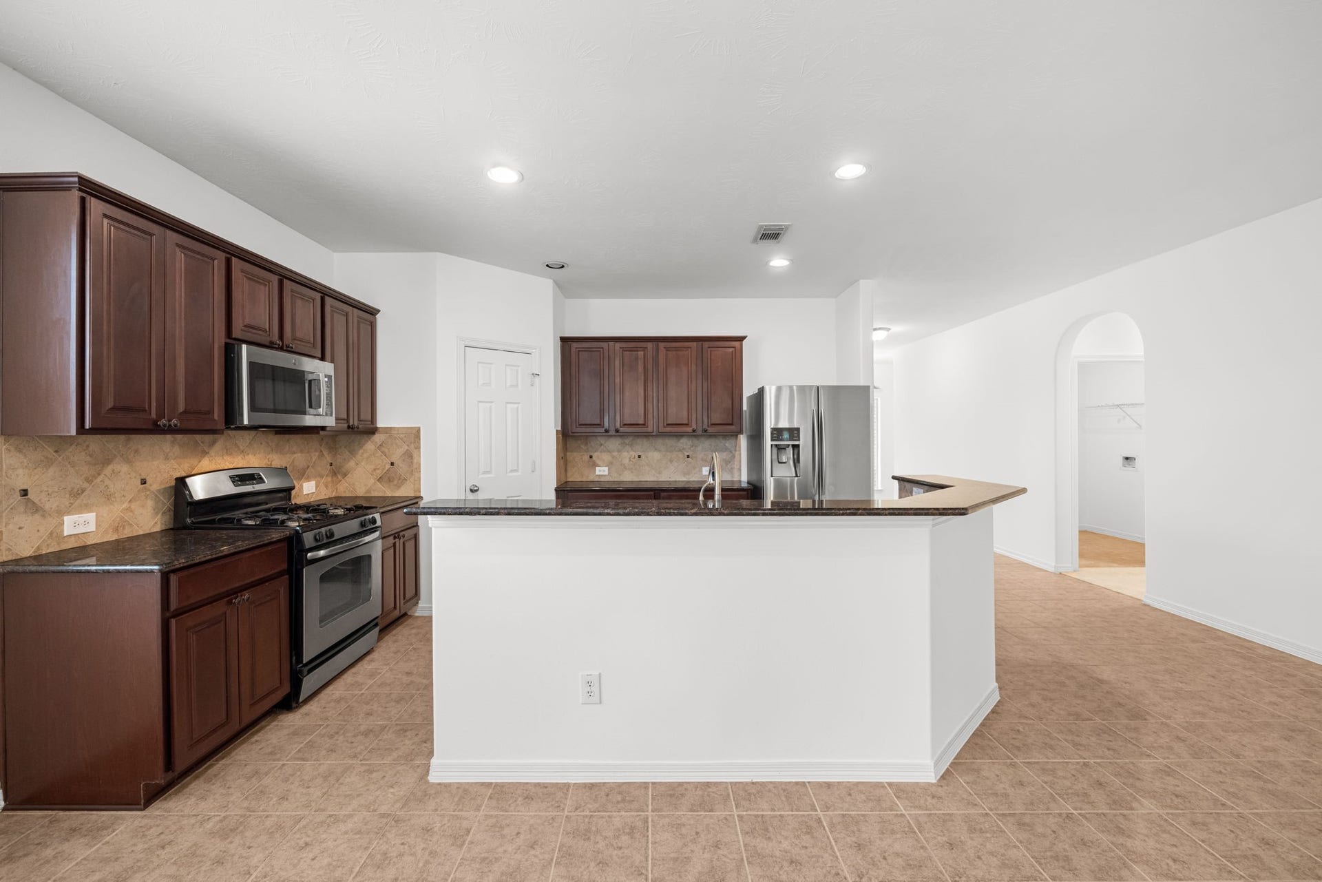 2006 Peonies Court, Pearland, TX 77581 Espresso-finished cabinetry accentuate the kitchen with rich contrast, while extensive countertops provide room to prepare meals, arrange serving dishes, and keep entertaining essentials close at hand.
