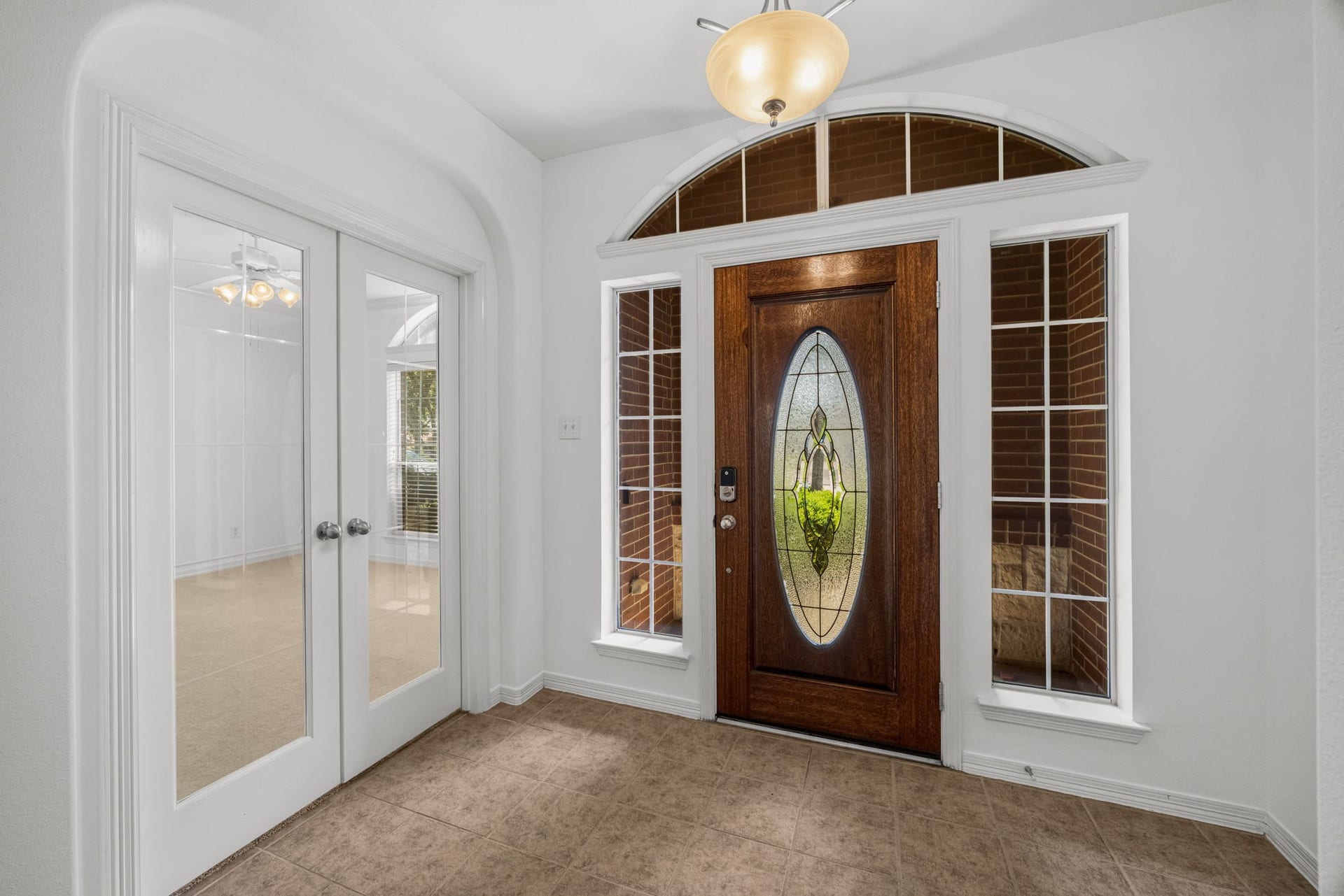 2006 Peonies Court, Pearland, TX 77581 An arched transom and sidelights bring added distinction to the front door, while adjacent glass-paneled double doors introduce a private study just off the foyer.