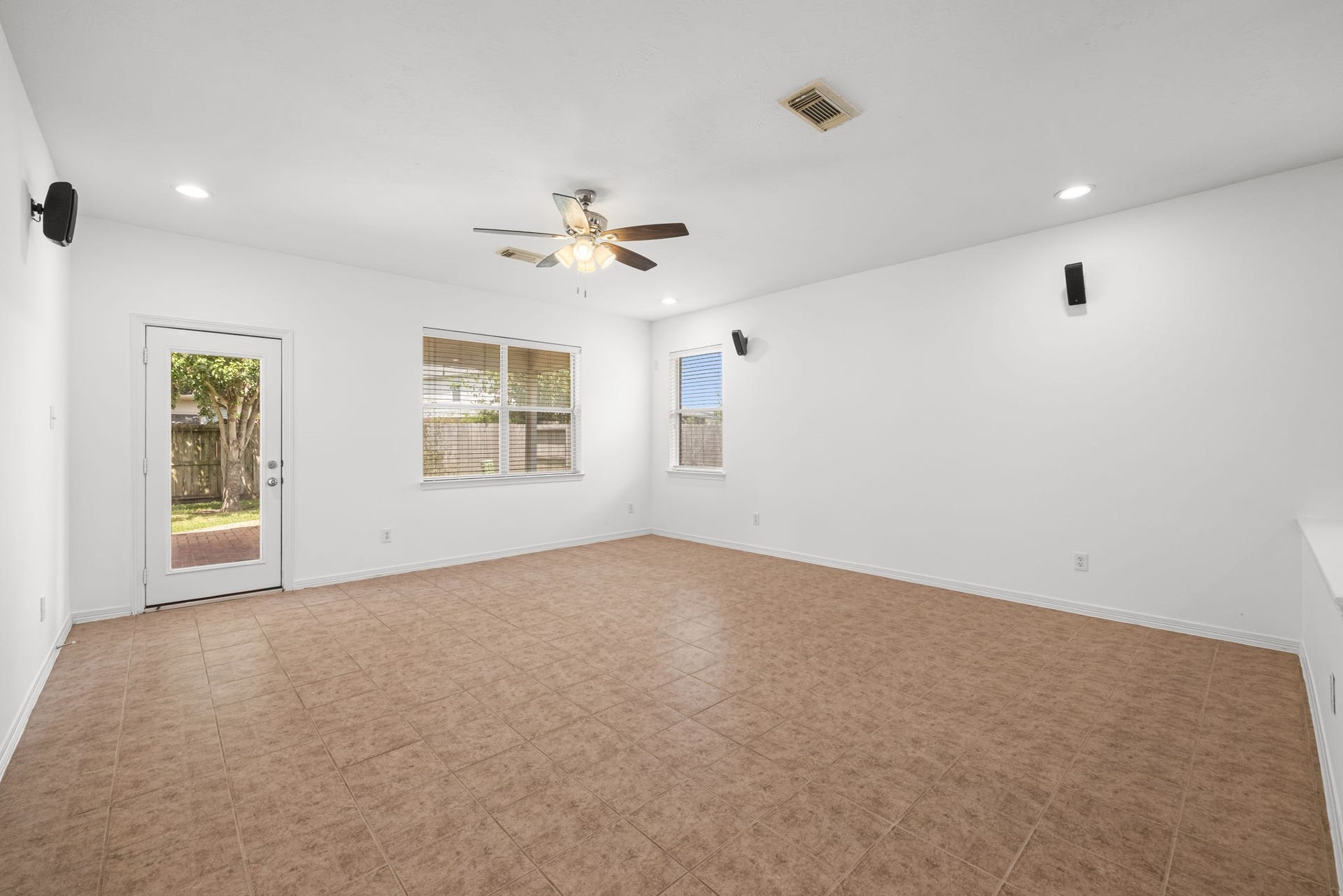 2006 Peonies Court, Pearland, TX 77581 Recessed lighting and a clean interior palette give the living room a fresh, open feel, while a glass-paneled door provides direct access to the covered rear patio for an easy change of scenery.