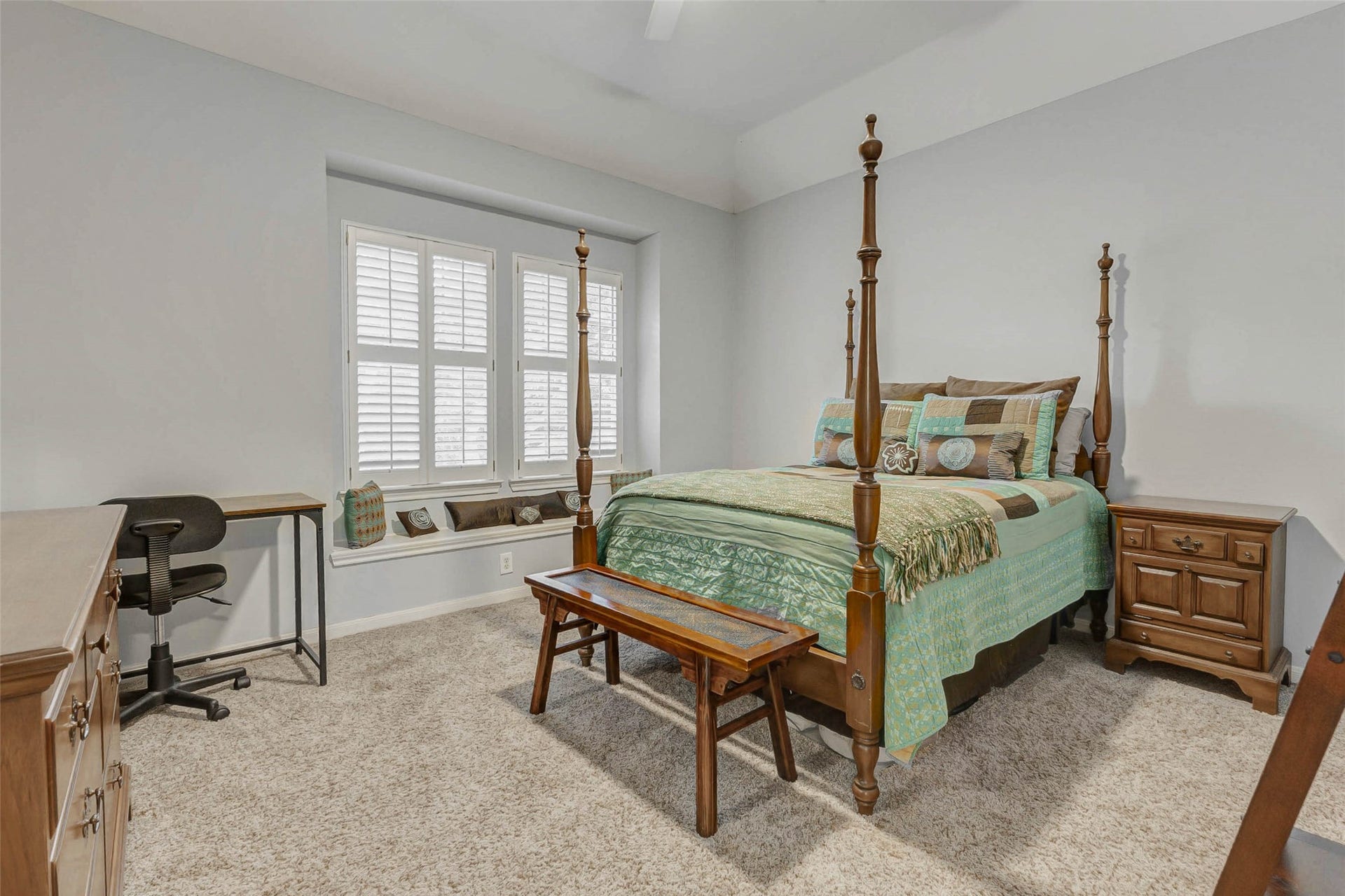 This bedroom features a window seat with shutters. The room has carpeted flooring and a neutral color palette, creating a warm and inviting atmosphere.  This room is across from the game room and has full bath next door.