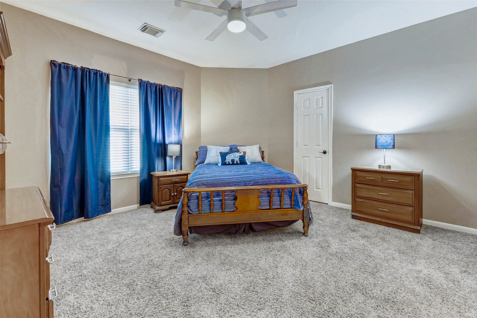 This cozy bedroom features soft carpet flooring, neutral walls, and a ceiling fan. It creates a warm and inviting atmosphere. Large walk in closet. Jack and Jill bathroom attached.