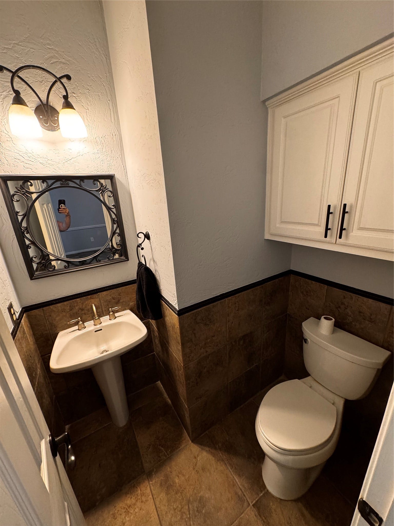 This bathroom features fresh painted walls (7/26) and decorative tiles. It includes a pedestal sink, wall cabinets, and a stylish mirror and light fixture.