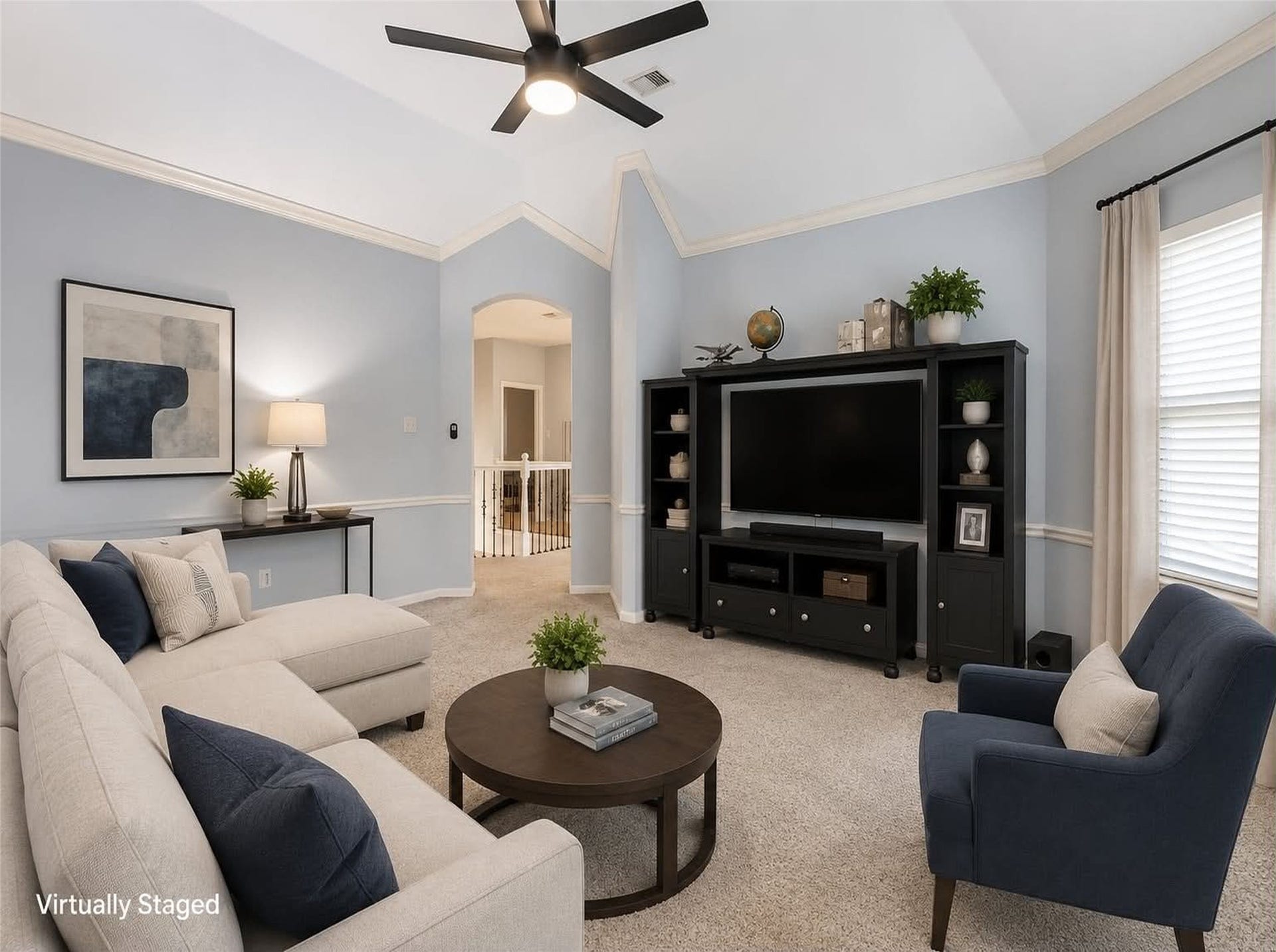 *virtually staged* Spacious game room with vaulted ceiling, neutral carpeting, and light grey walls. Room for a large entertainment center, 3 large windows with views of the backyard. The gameroom is set off of the upstairs hall and closed off to the downstairs.