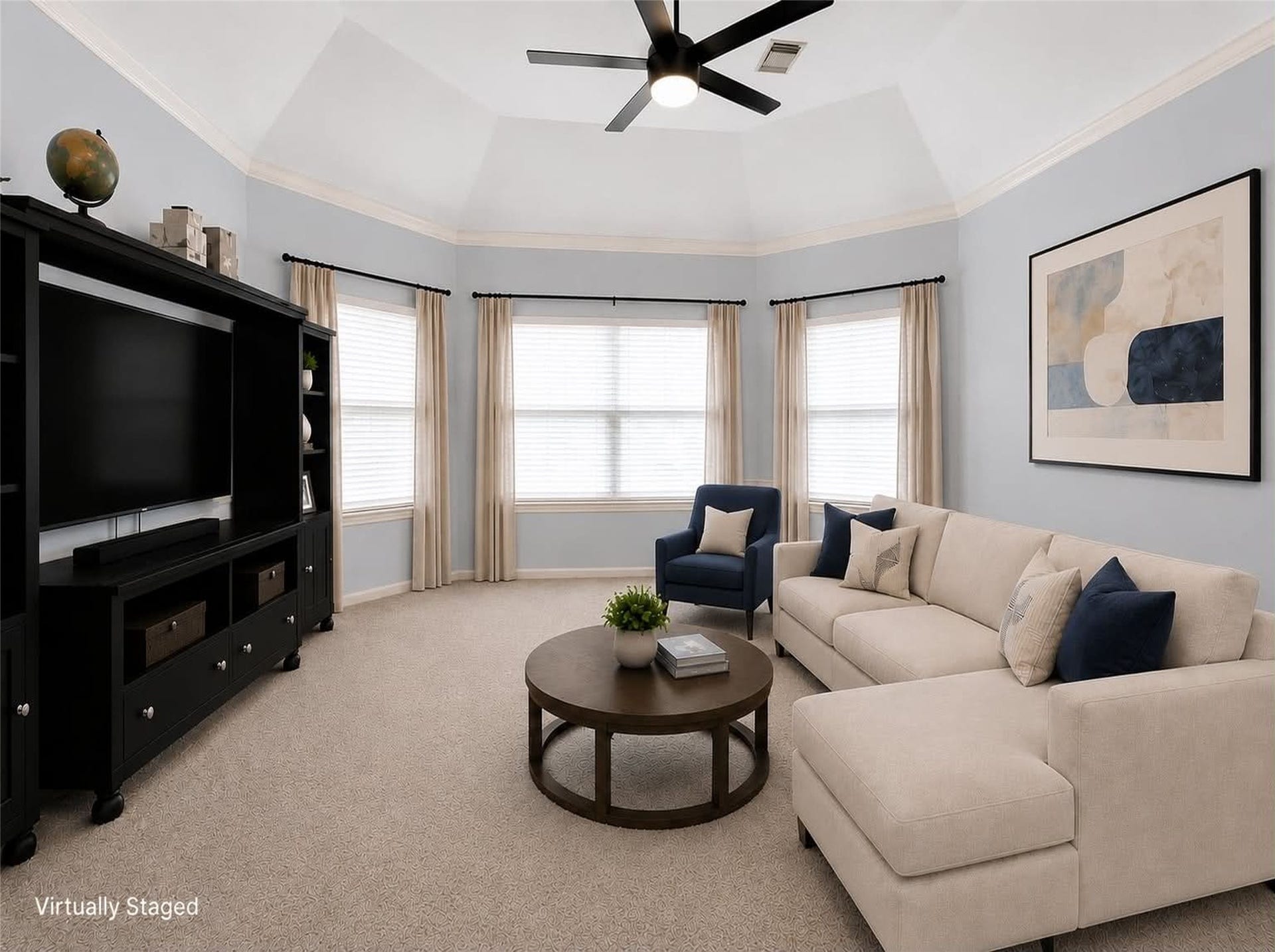 *virtually staged* This spacious game room features cozy carpet, large windows providing natural light, and a ceiling fan. The neutral tones offer a versatile backdrop for personal decor.