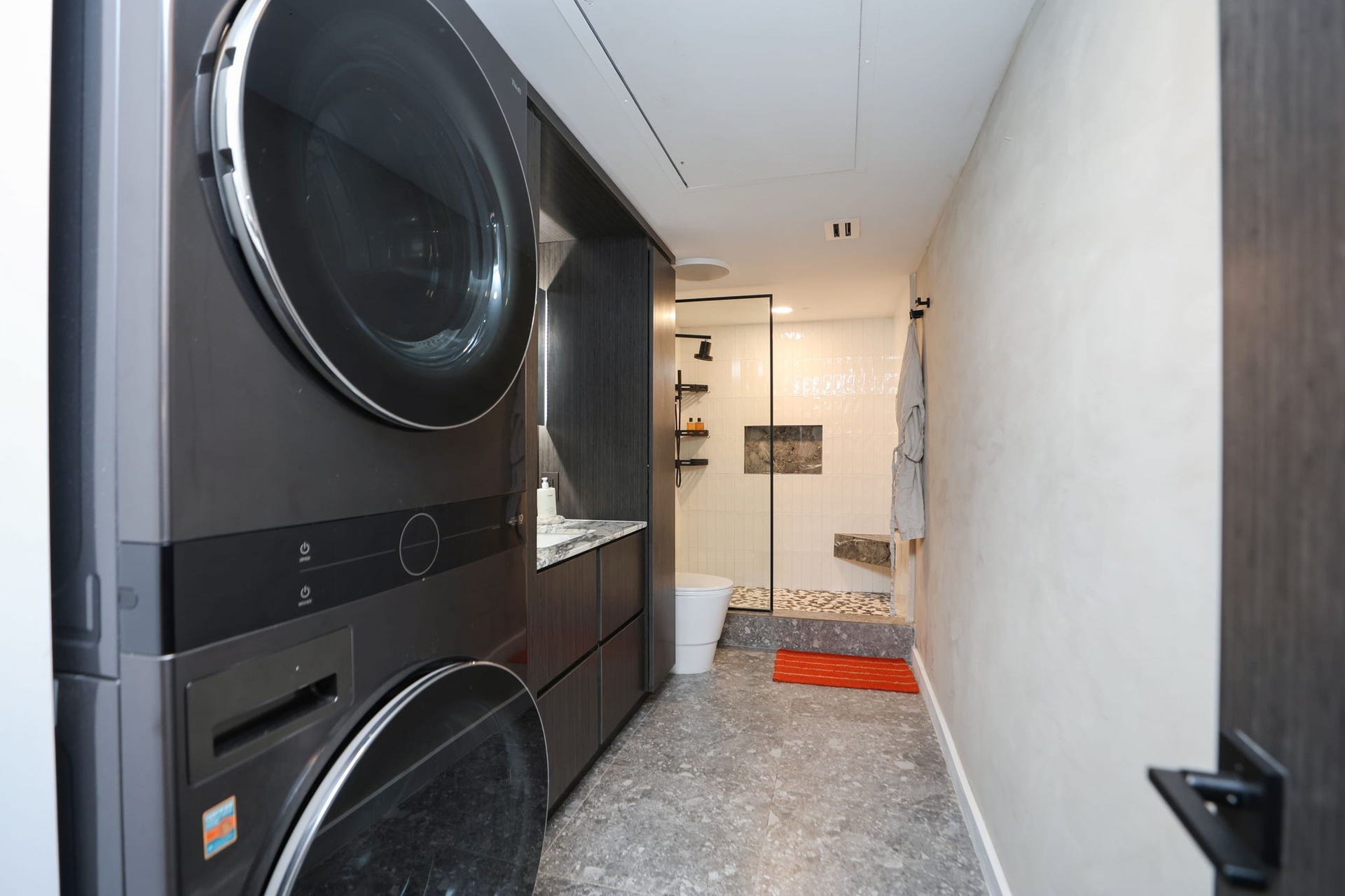 LG full-size stackable washer and dryer are located in the primary bathroom. Smart lighting in bathroom.