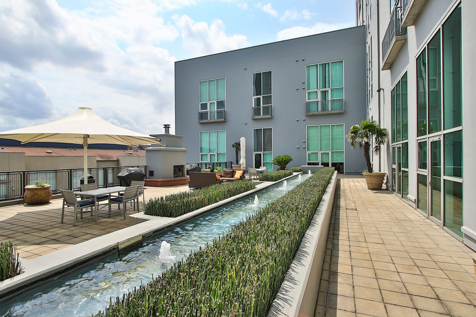 5th floor Eden offers a lush garden deck with Zen fountain, fireplace, grills, and shady gathering umbrellas. Relax or entertain in this outdoor space.
