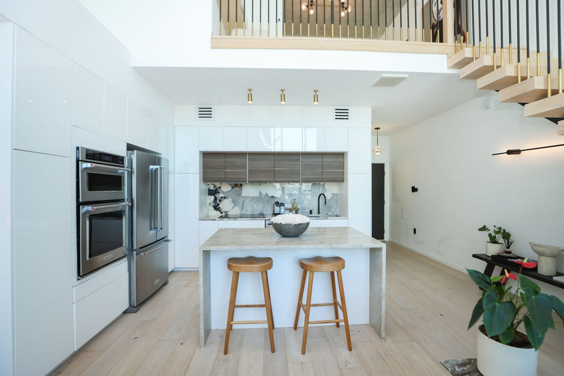 Upscale finished from floor to ceiling, including wide plank white oak engineered flooring, Calcutta marble, and brass accent lighting.