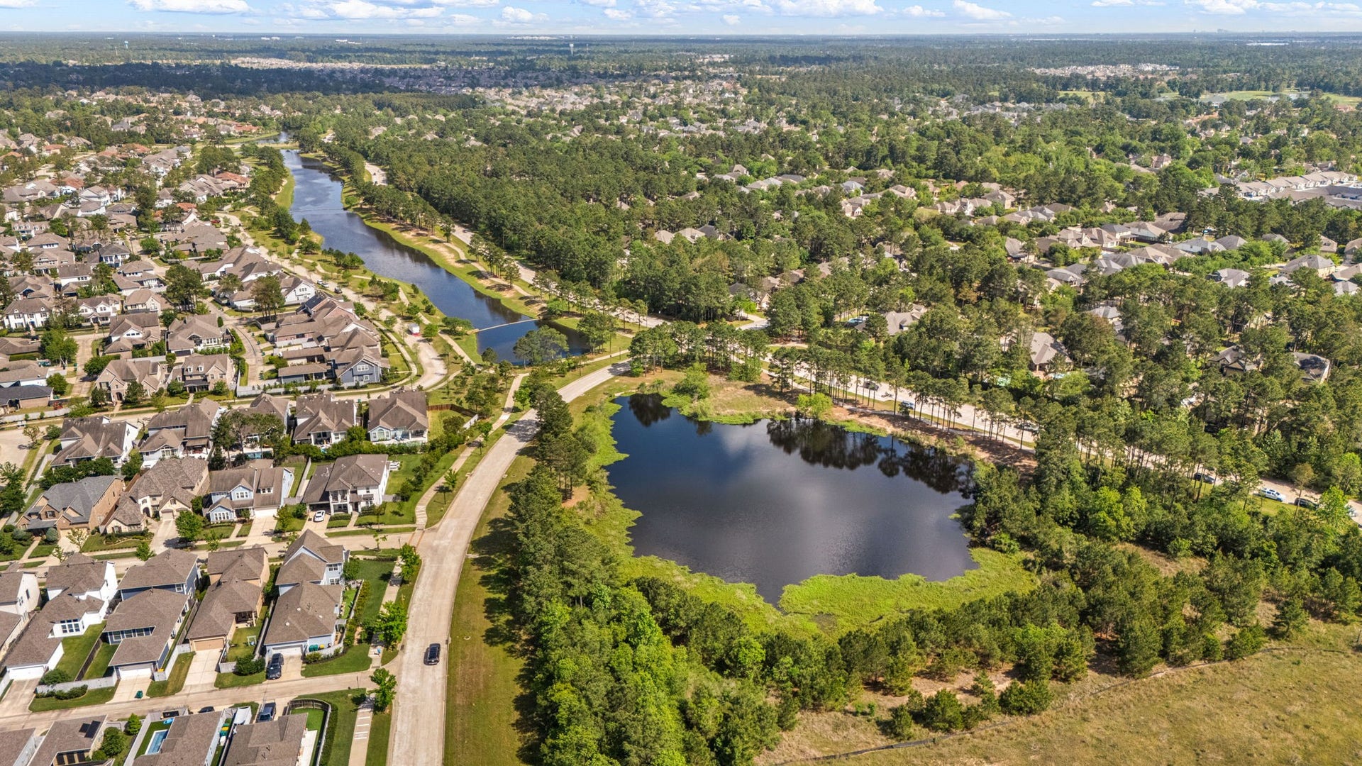 14 Kendrick Pines Boulevard, The Woodlands, TX 77389 This expansive aerial view highlights the community lake that weave through the neighborhood, offering residents miles of scenic trails and peaceful waterfront vistas. Perfectly positioned to embrace the outdoors while remaining just minutes from the vibrant amenities of The Woodlands, this is truly the pinnacle of suburban living.