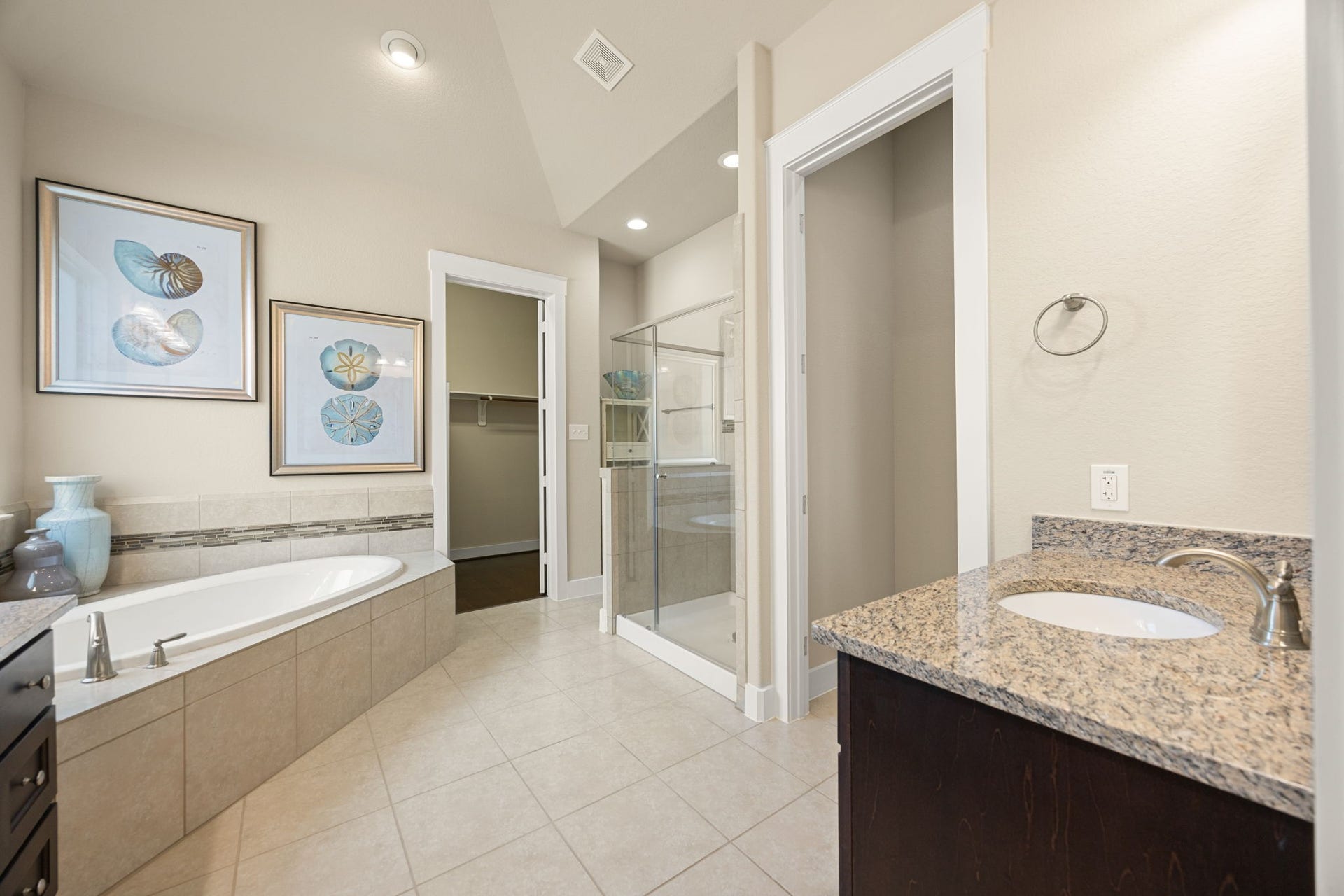 14 Kendrick Pines Boulevard, The Woodlands, TX 77389 A deep soaking garden tub is perfectly positioned under large windows, inviting you to relax in a sun-drenched sanctuary. The separate, glass-enclosed walk-in shower and premium tile flooring complete this refined retreat, offering the ultimate in daily comfort and style.