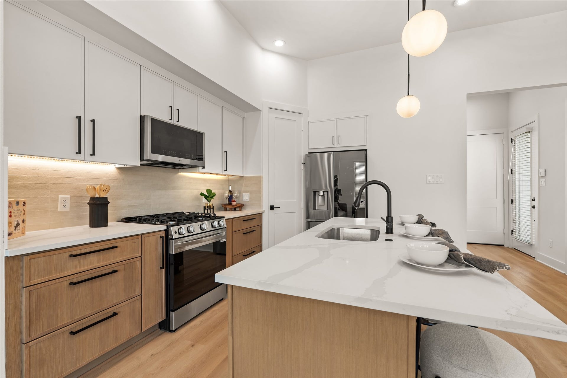 High-end kitchen layout featuring an undermount island sink, walk-in pantry, and modern finishes.