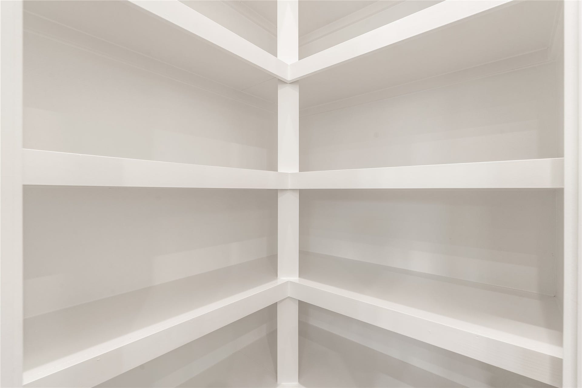 Large walk-in pantry offering multi-tier built-in shelving for optimal food storage.