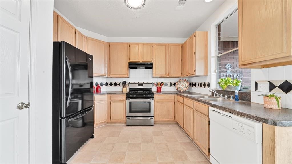 2919 Blue Dawn Drive, Katy, TX 77449 The kitchen offers 42-inch cabinets, ample counter space, a gas range, refrigerator, and dishwasher.