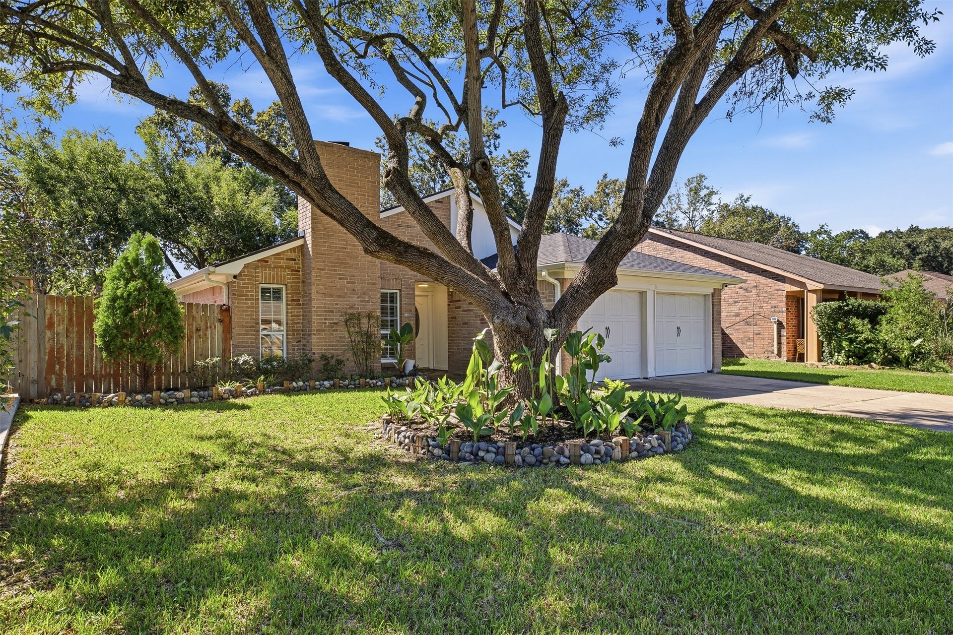 22611 Carter Moir Lane, Katy, TX 77449 Beautiful brick exterior surrounded by mature trees, manicured landscaping, and an attached two-car garage.