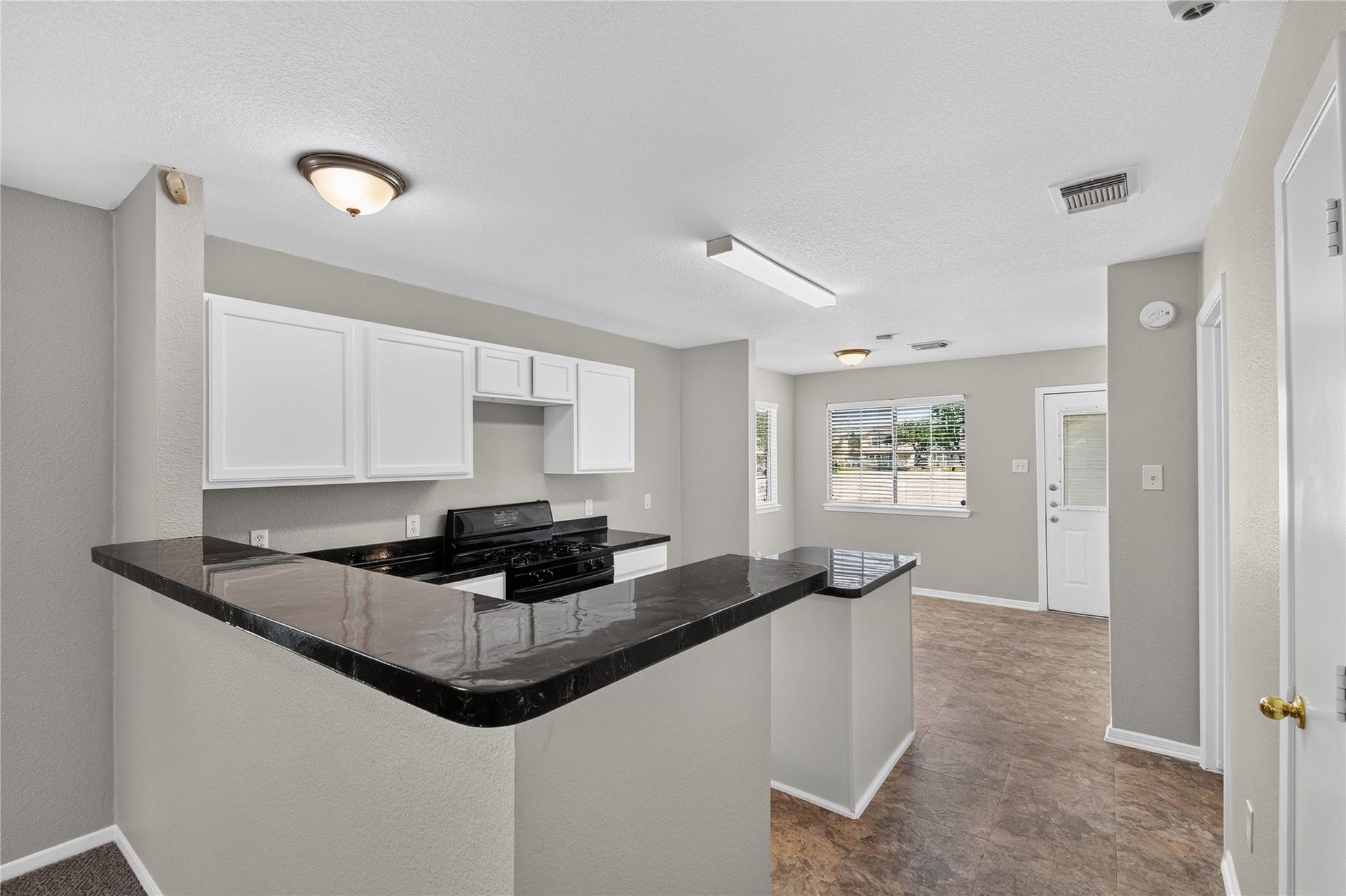 19547 Fletcher Way Drive, Houston, TX 77073 The kitchen features crisp white cabinetry, black countertops, a gas range, and a convenient breakfast bar.