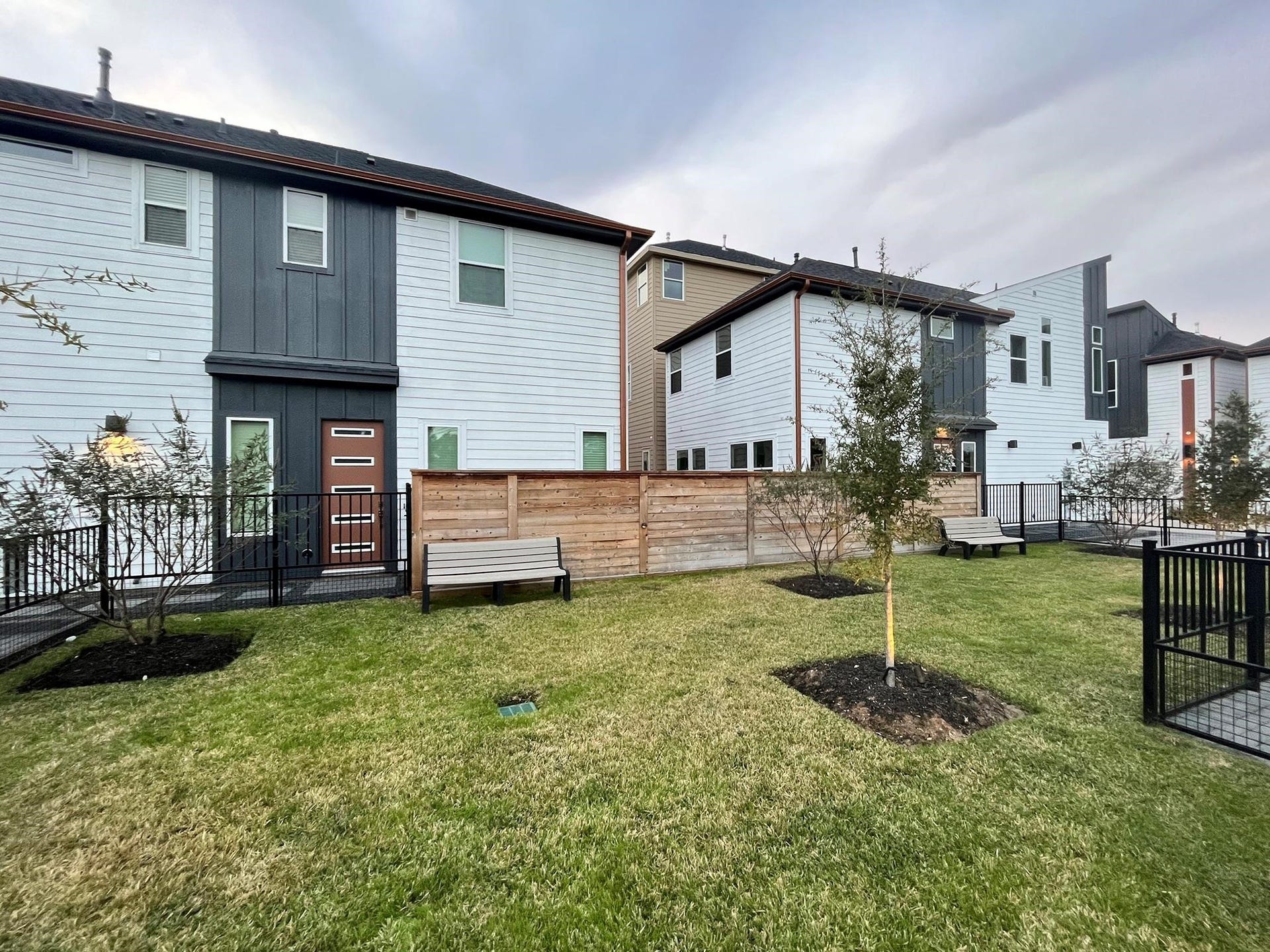 751 N Emile Street, Houston, TX 77020 Modern homes with sleek exteriors, fenced yards, and a landscaped communal area featuring benches and trees.
Note: Photos 2022