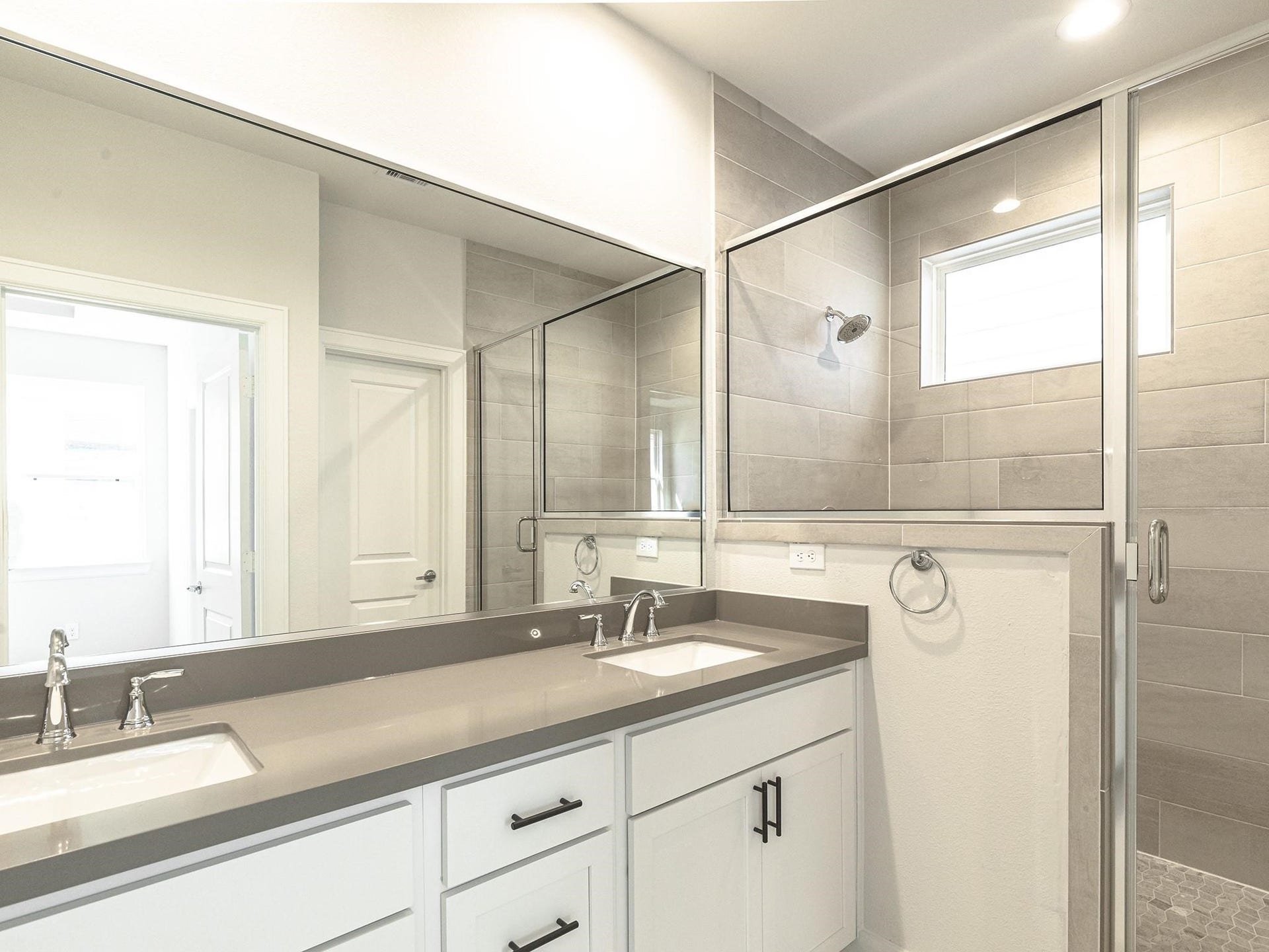751 N Emile Street, Houston, TX 77020 Modern primary bathroom featuring a spacious dual-sink vanity with sleek fixtures and a glass-enclosed shower, highlighted by elegant tile work and ample natural light.
Note: Photos 2022