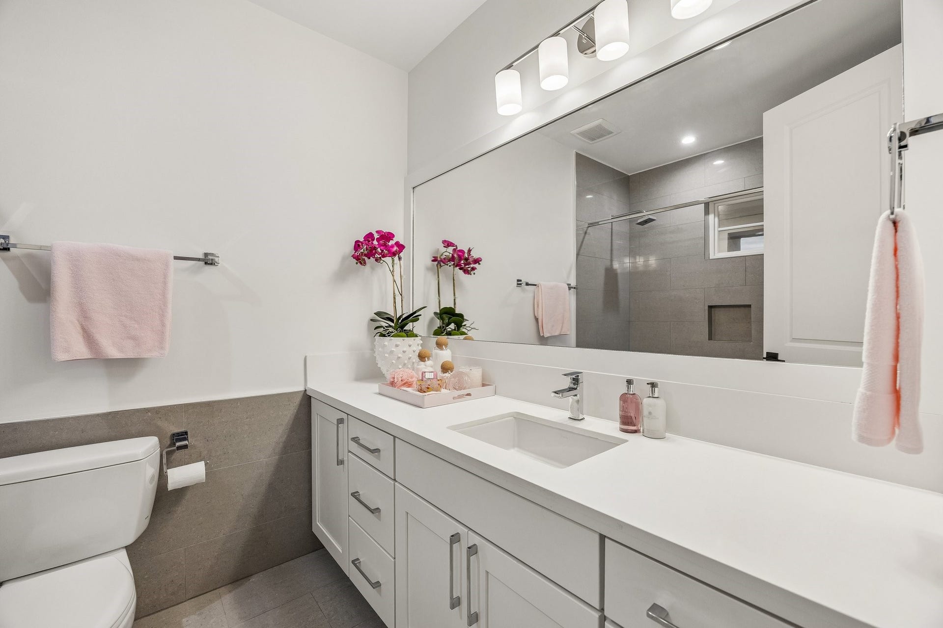 Generous size en-suite baths in all bedrooms.  Shaker style cabinetry, slab quartz counter,underount sink, framed mirror and pedent lighting.