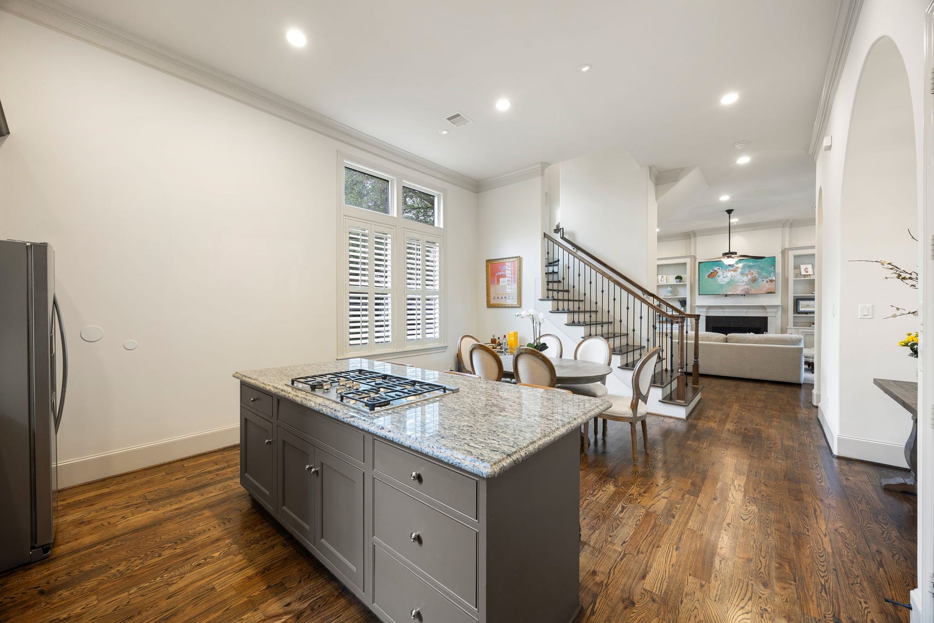 310 W Bell Street, Houston, TX 77019 The open-concept floor plan flows seamlessly into a dining area and living room perfect for hosting or enjoying time with family. The hardwood floors, 12' ceilings through out give such an elevated feel. The staircase leads to the upstairs bedrooms.