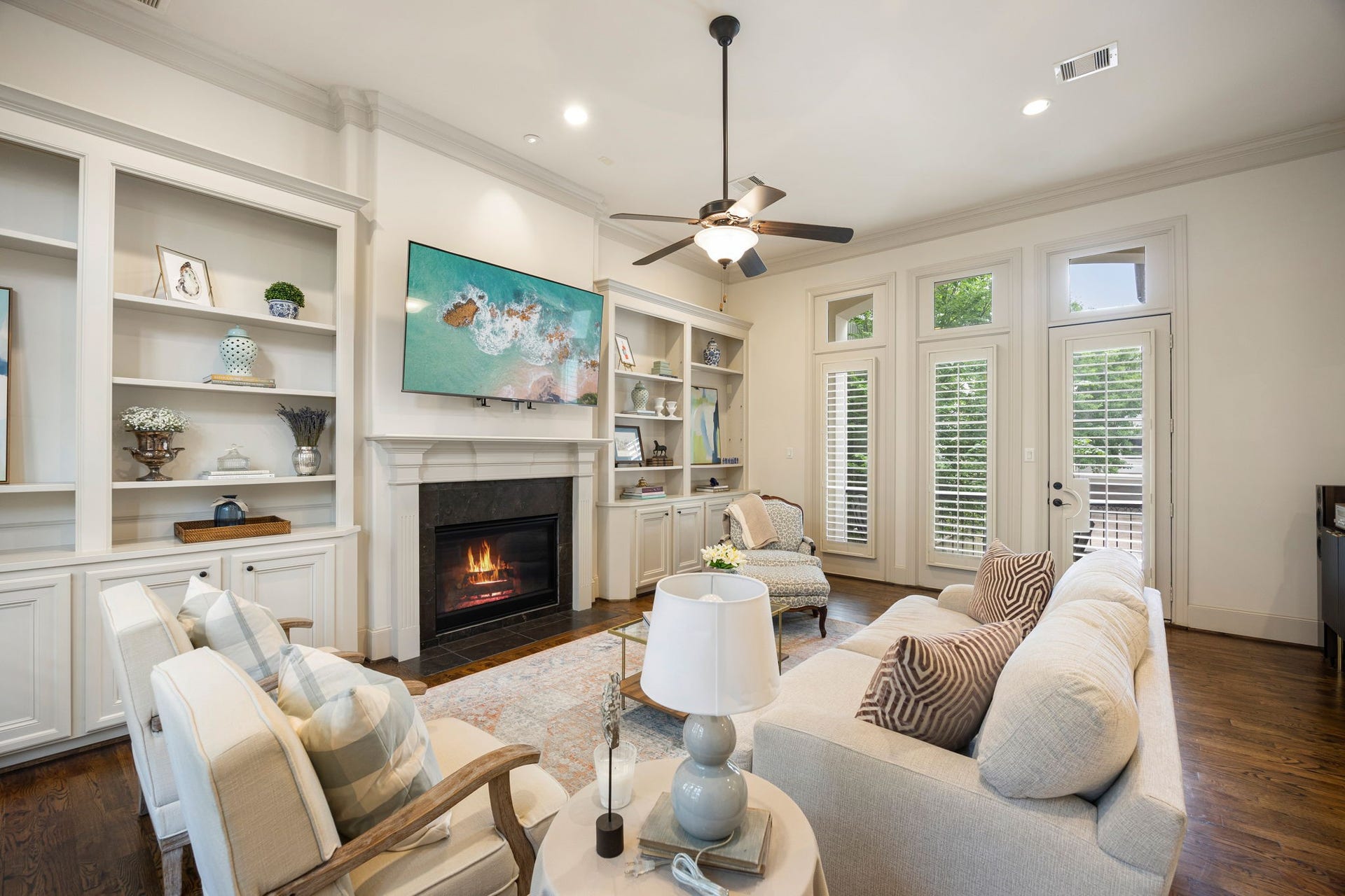 310 W Bell Street, Houston, TX 77019 The 2nd floor living room is inviting and features an elegant fireplace, built-in shelving, and beautiful hard wood floors. The French doors lead to an outdoor balcony with views of the lush courtyard below.