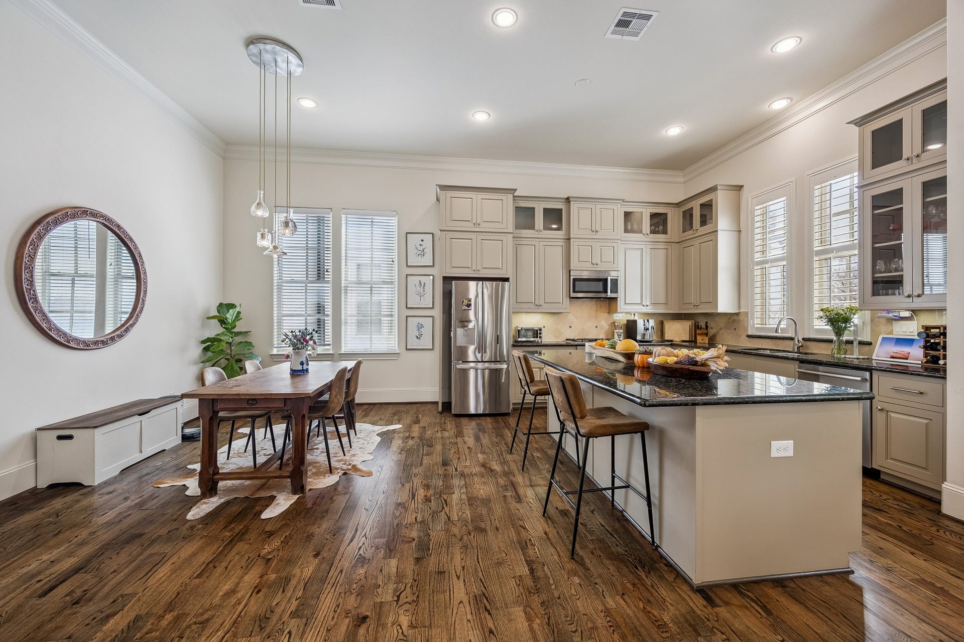2721 Cohn Street, Houston, TX 77007 Light-filled kitchen & dining area features wood floors, tall cabinetry, stainless steel appliances, granite counters & breakfast bar seating, w/multiple windows bringing natural light into the space.