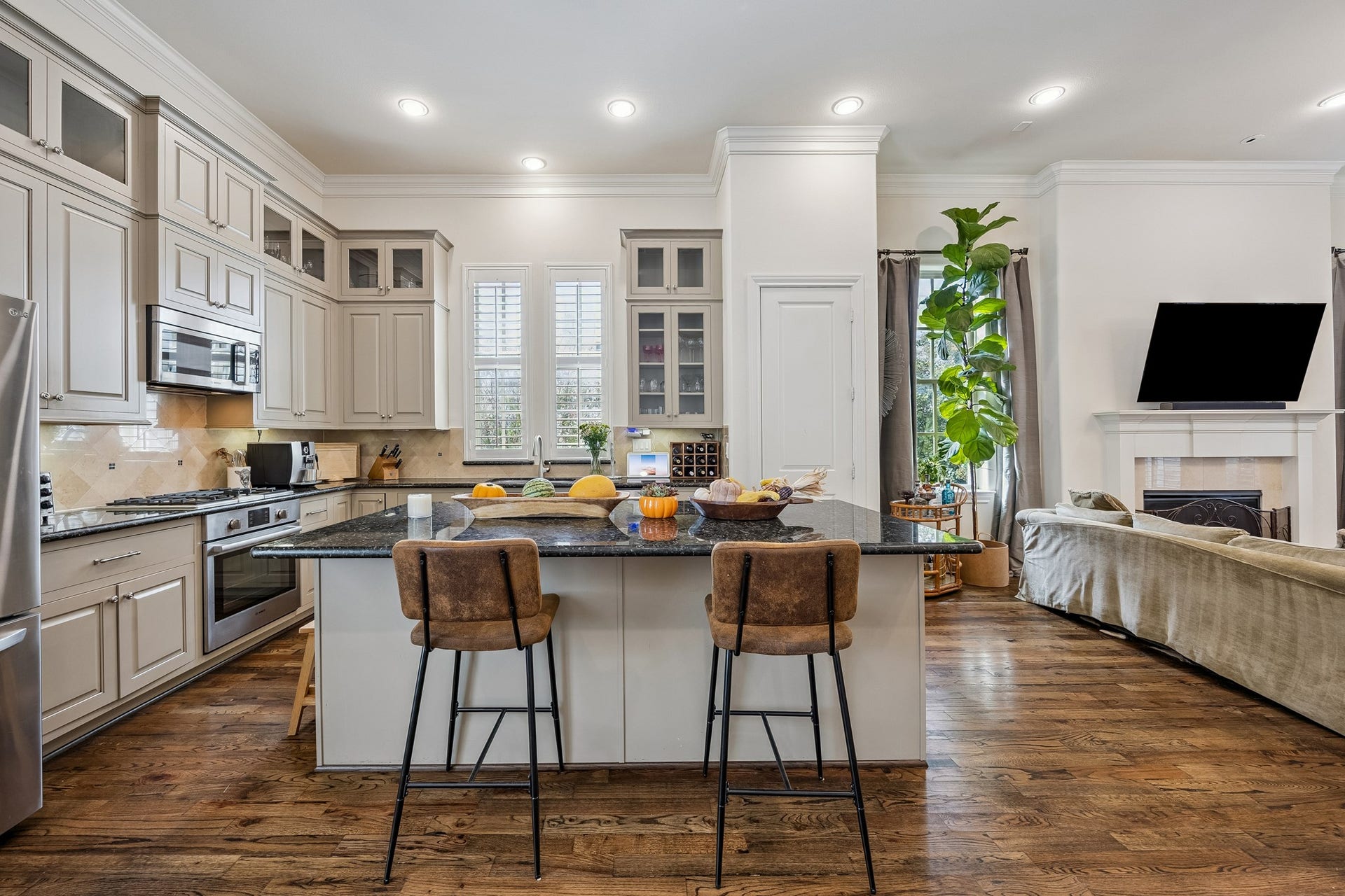 2721 Cohn Street, Houston, TX 77007 Open kitchen connects seamlessly to the living area & features a large granite island w/breakfast bar seating, extensive cabinetry, stainless steel appliances, crown molding & recessed lighting.